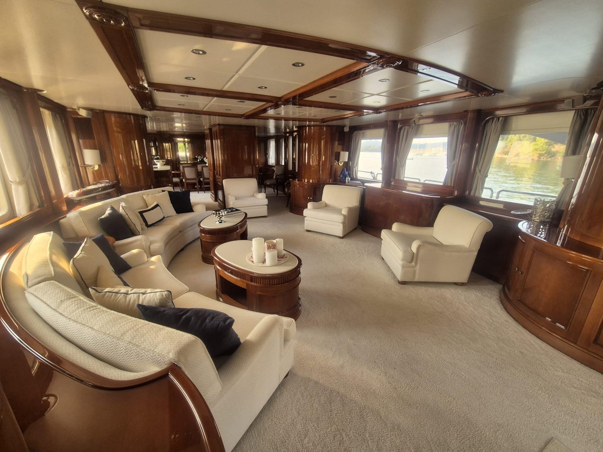Luxurious interior of a 2000 Benetti Classic 115 yacht with elegant seating and wood finishes.