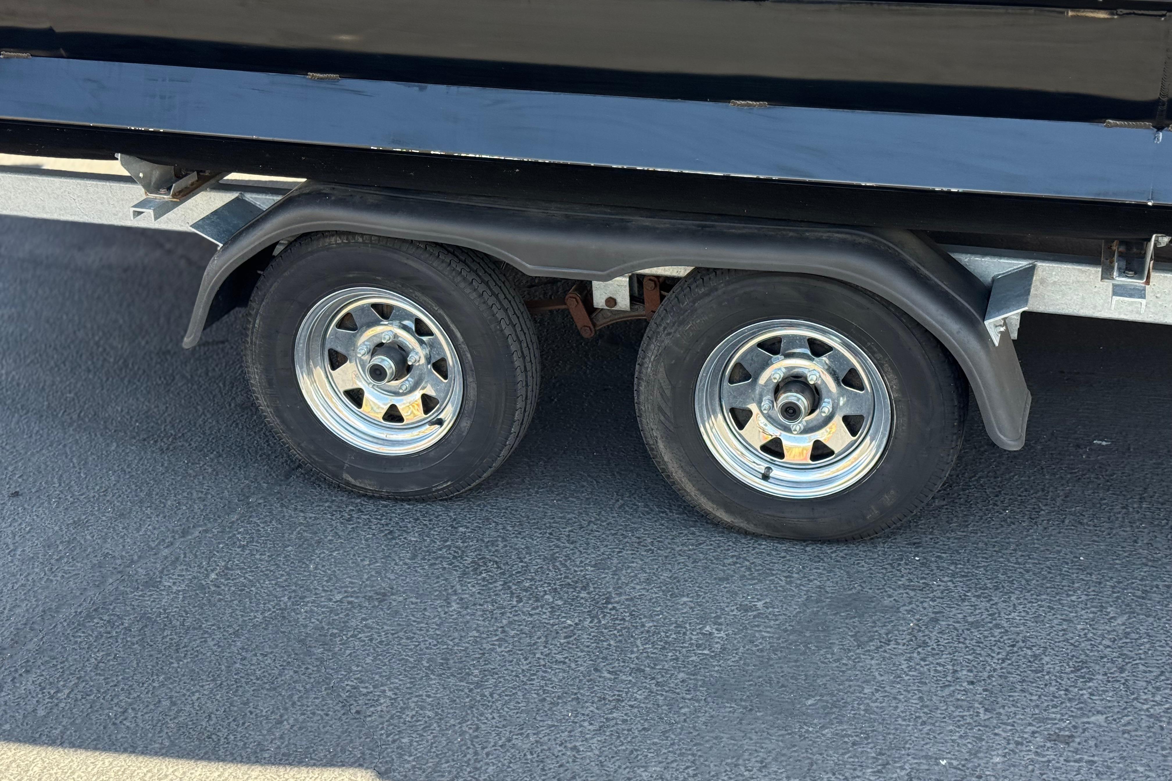 Dual wheels of a 2023 Lexington 623 ST Xtreme trailer on asphalt surface.