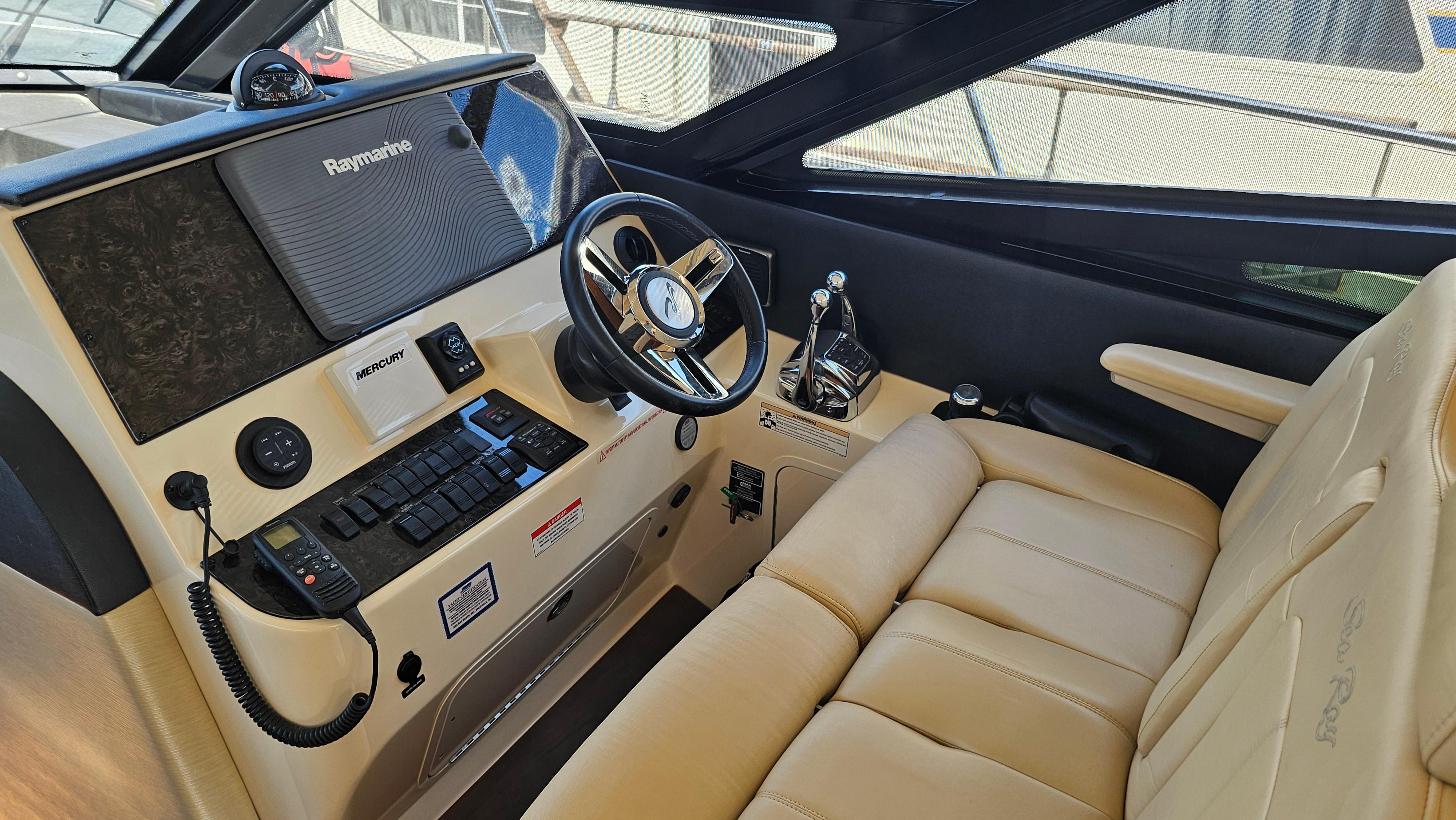 2016 Sea Ray 470 Sundancer helm with beige leather seating and advanced navigation controls.