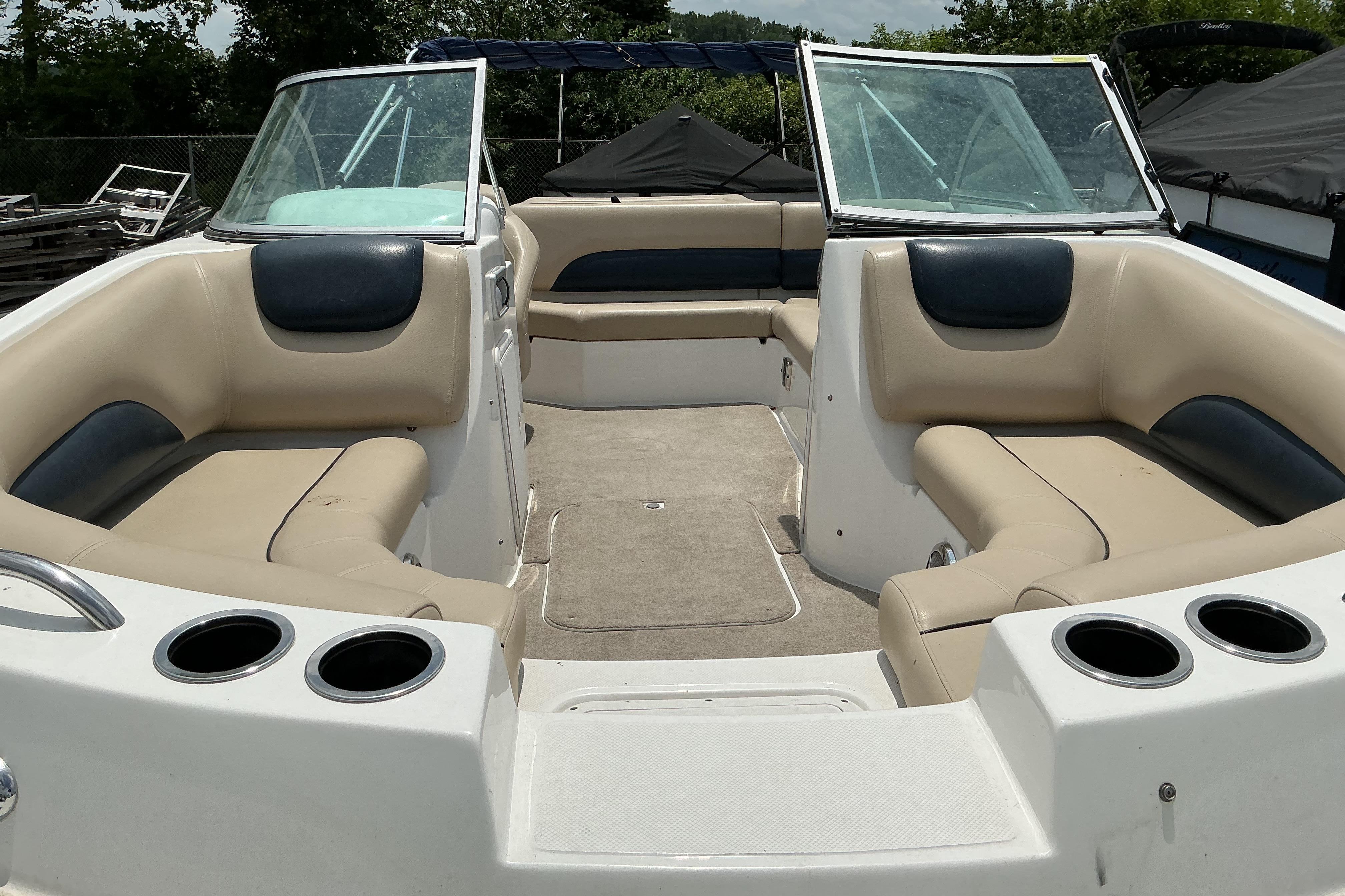 2015 Hurricane SunDeck 187 IO boat interior with beige seating and cup holders.