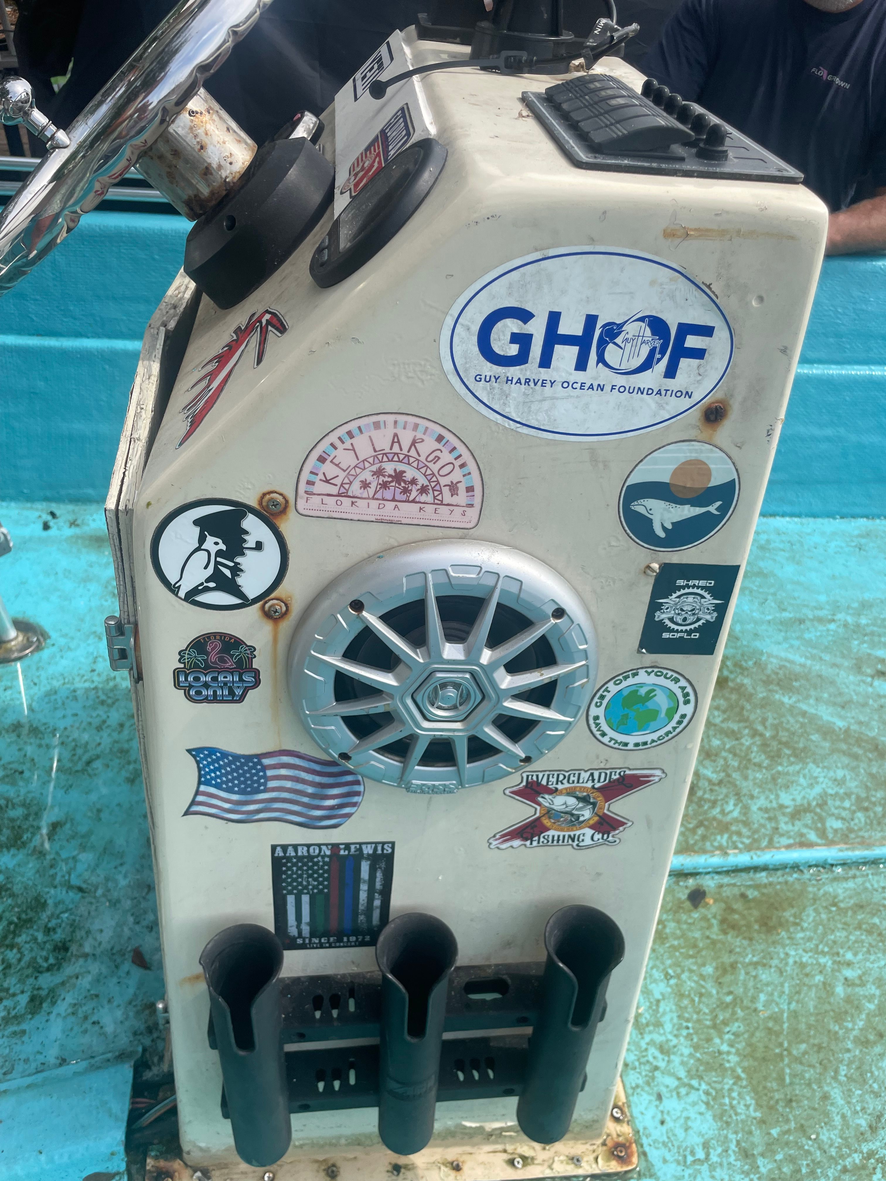 Boat console with stickers and a speaker.
