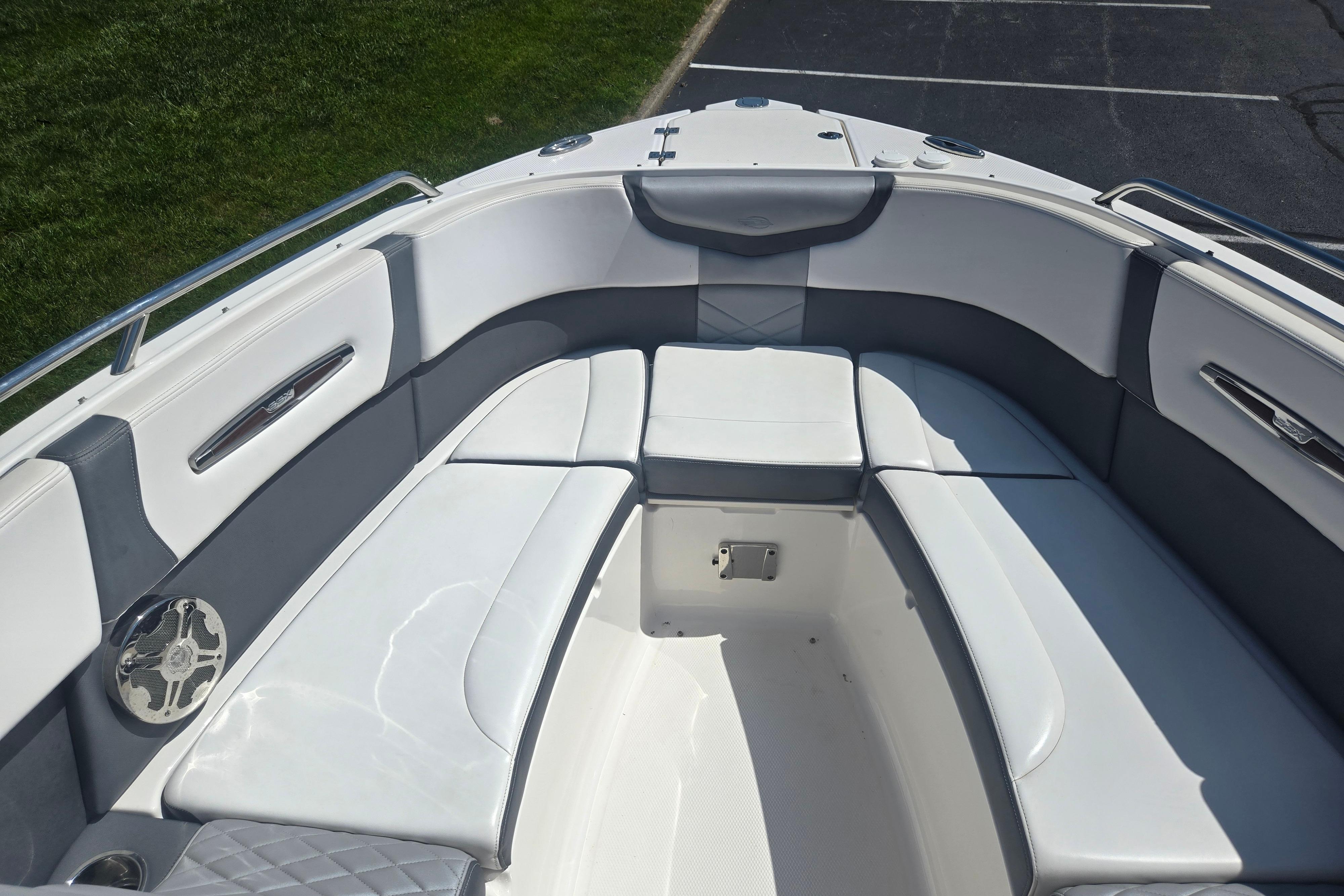 2018 Chaparral 267 SSX boat interior with white and gray seating, parked on grass.