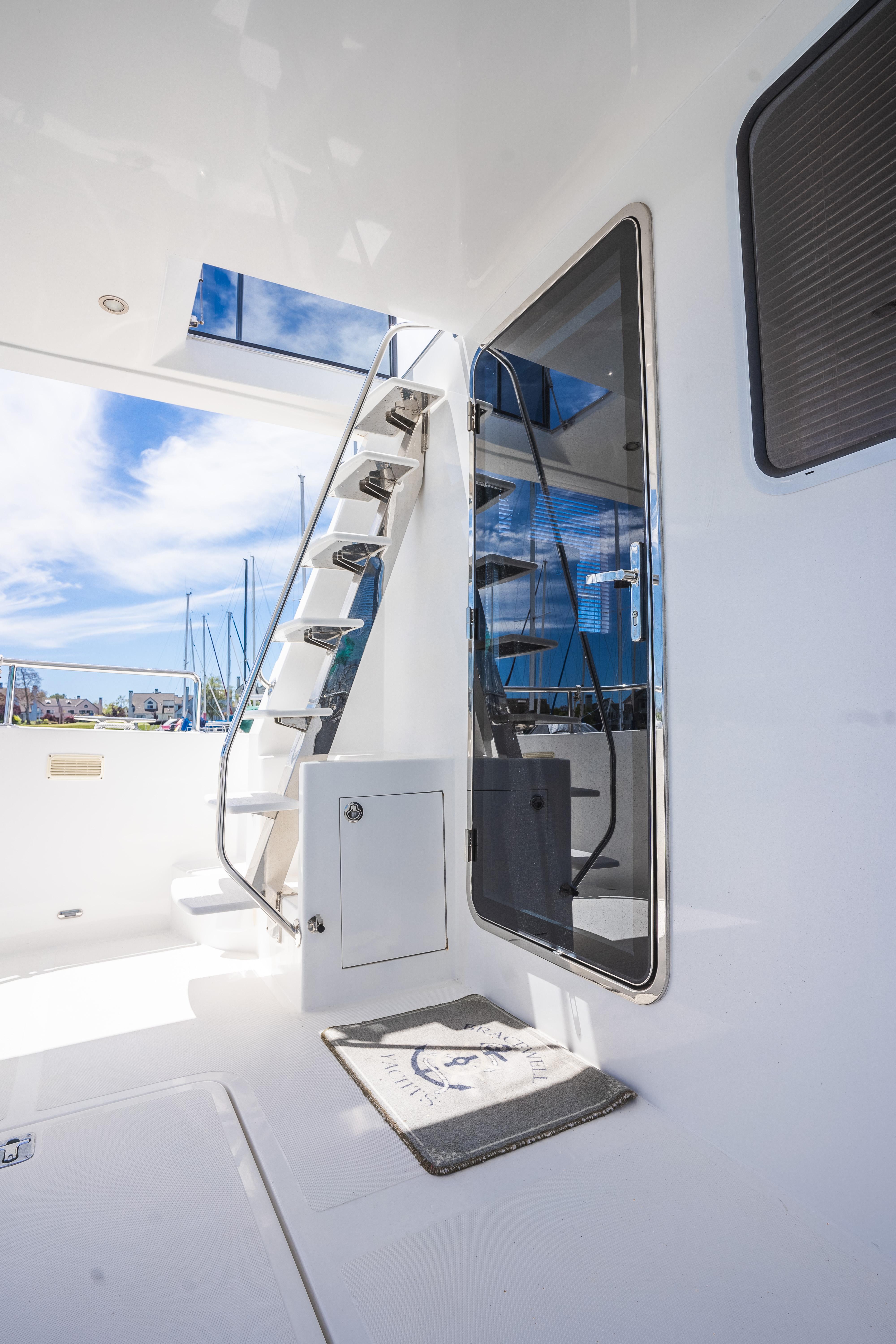 Modern Bracewell 41 yacht interior with sleek stairs and glass door, 2025 model.
