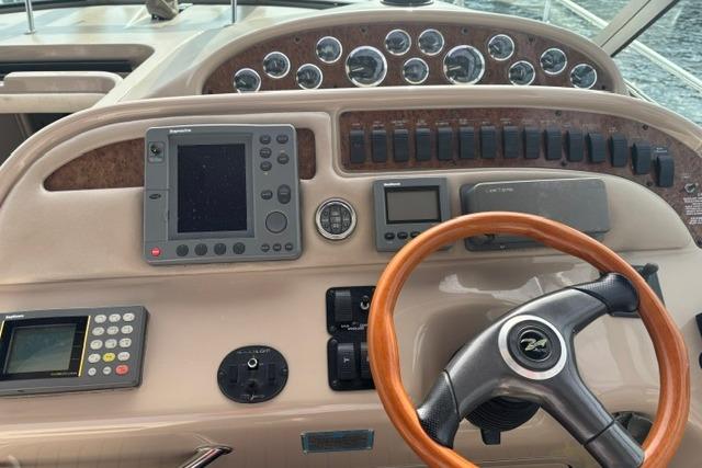 Cockpit of 2000 Sea Ray Sundancer 310 with steering wheel and navigation instruments.