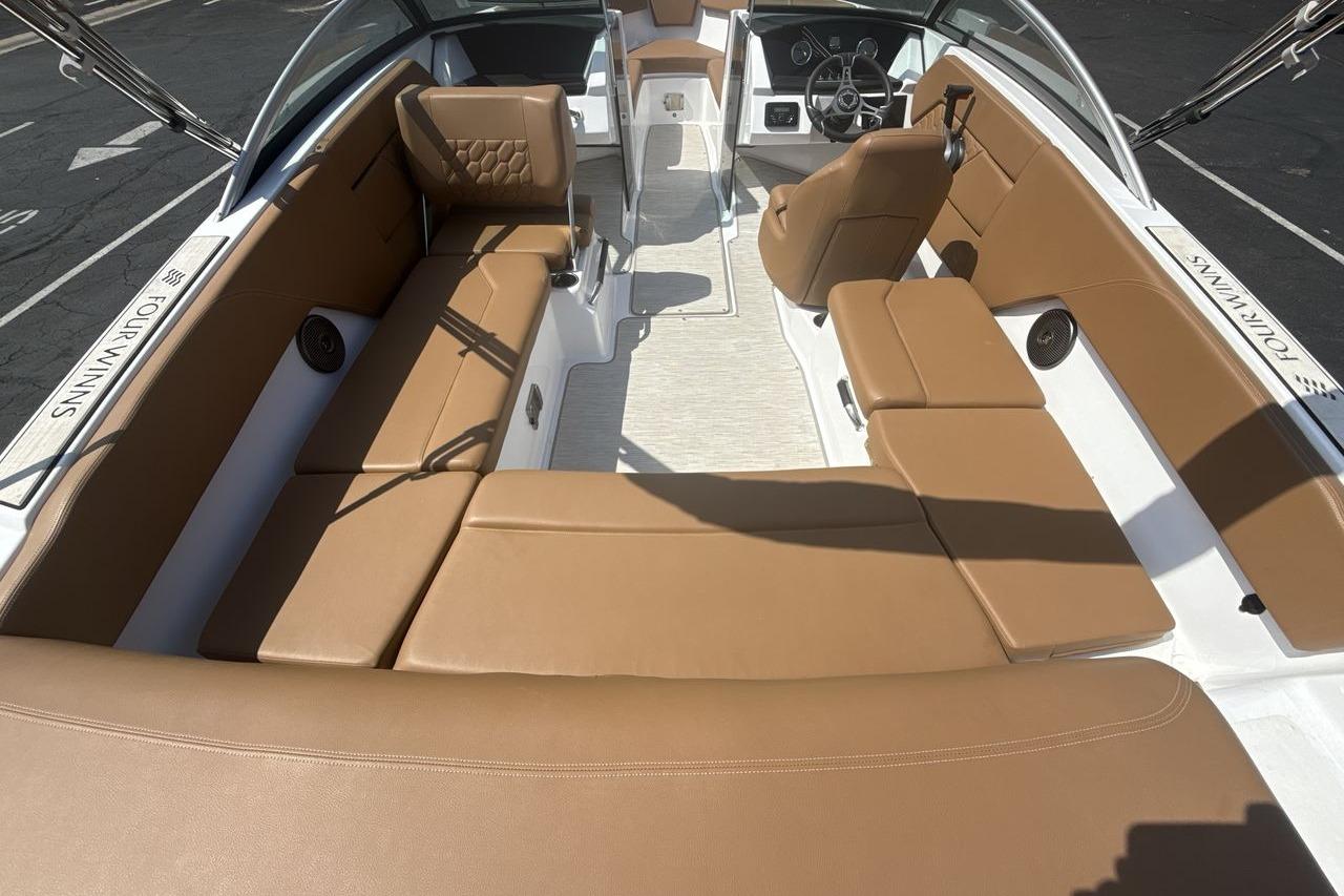 2024 Four Winns H1 OB boat interior with tan seating and modern dashboard.