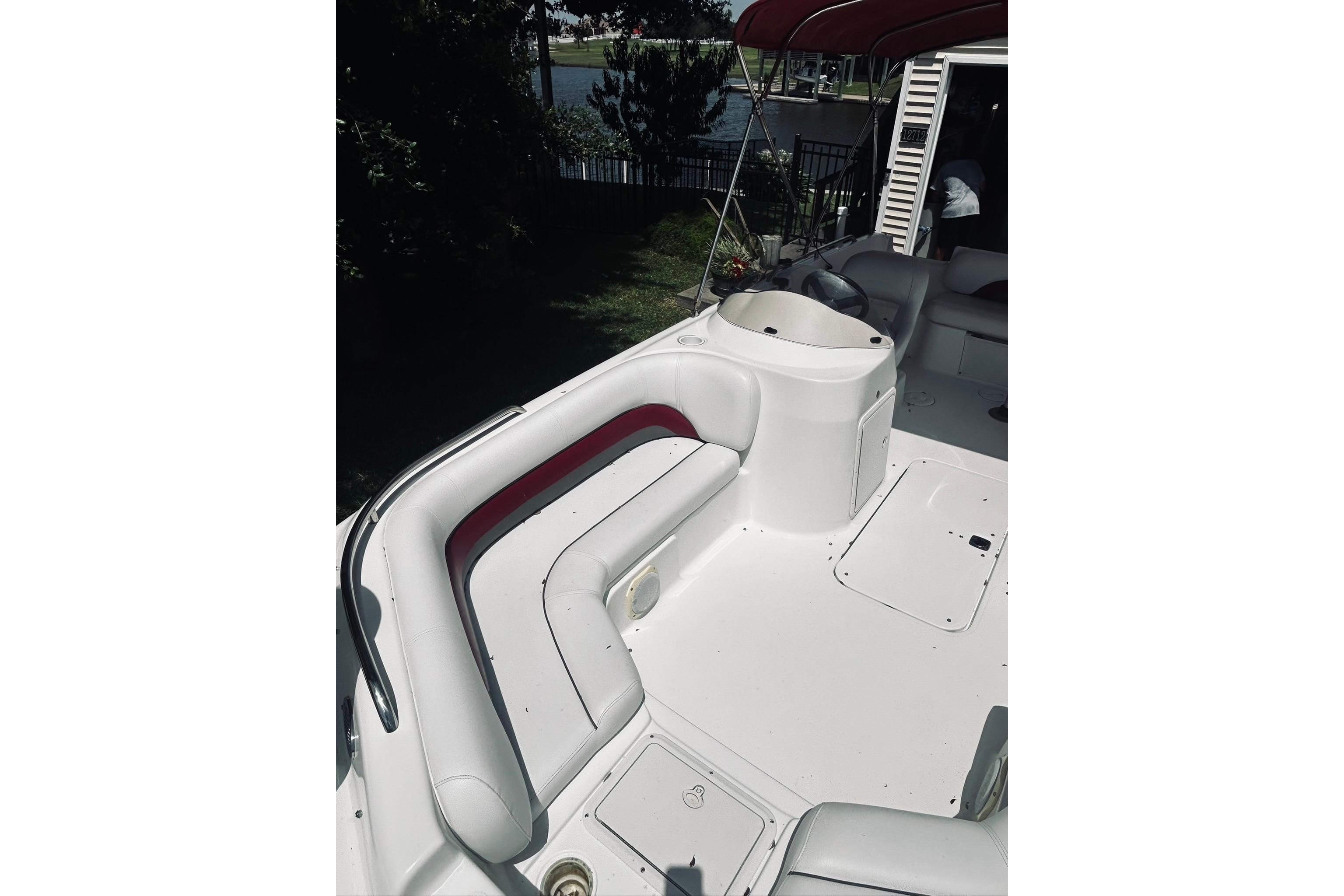 2013 Hurricane SunDeck Sport 201 OB boat interior with seating and helm, near waterfront.