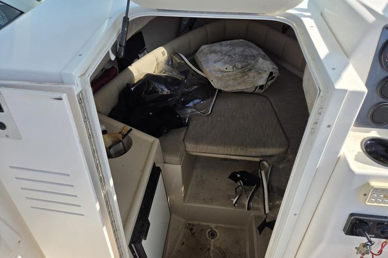 2004 Robalo R235 Walkaround cabin interior with seating and storage.