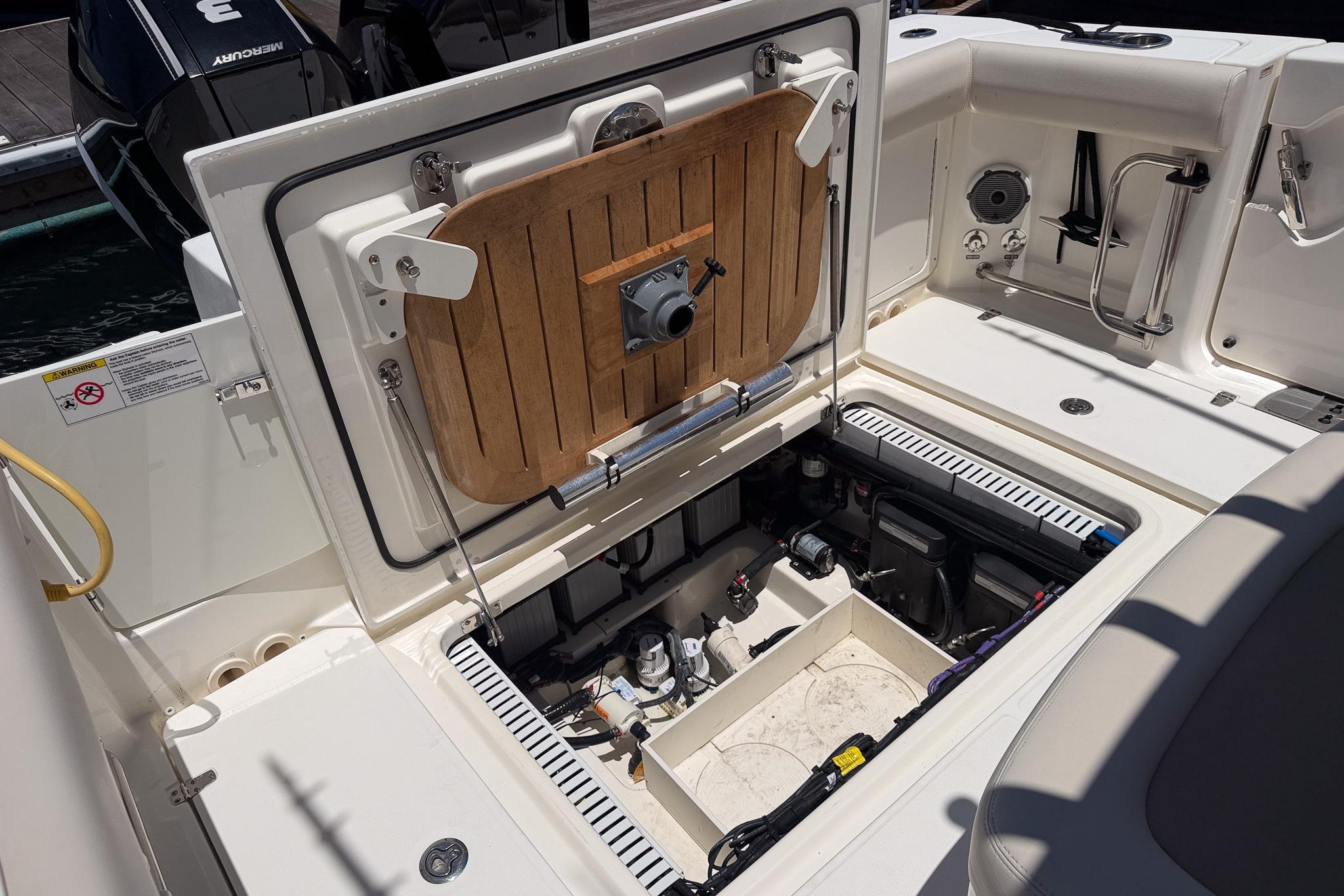2021 Boston Whaler 330 Outrage boat interior showing open storage compartment and equipment.