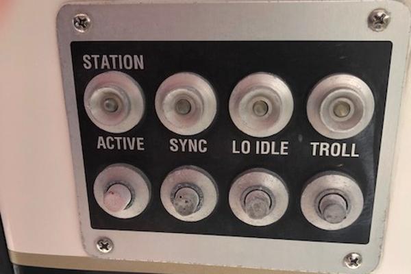 Control panel of a 1997 Bertram Convertible boat with various function buttons.