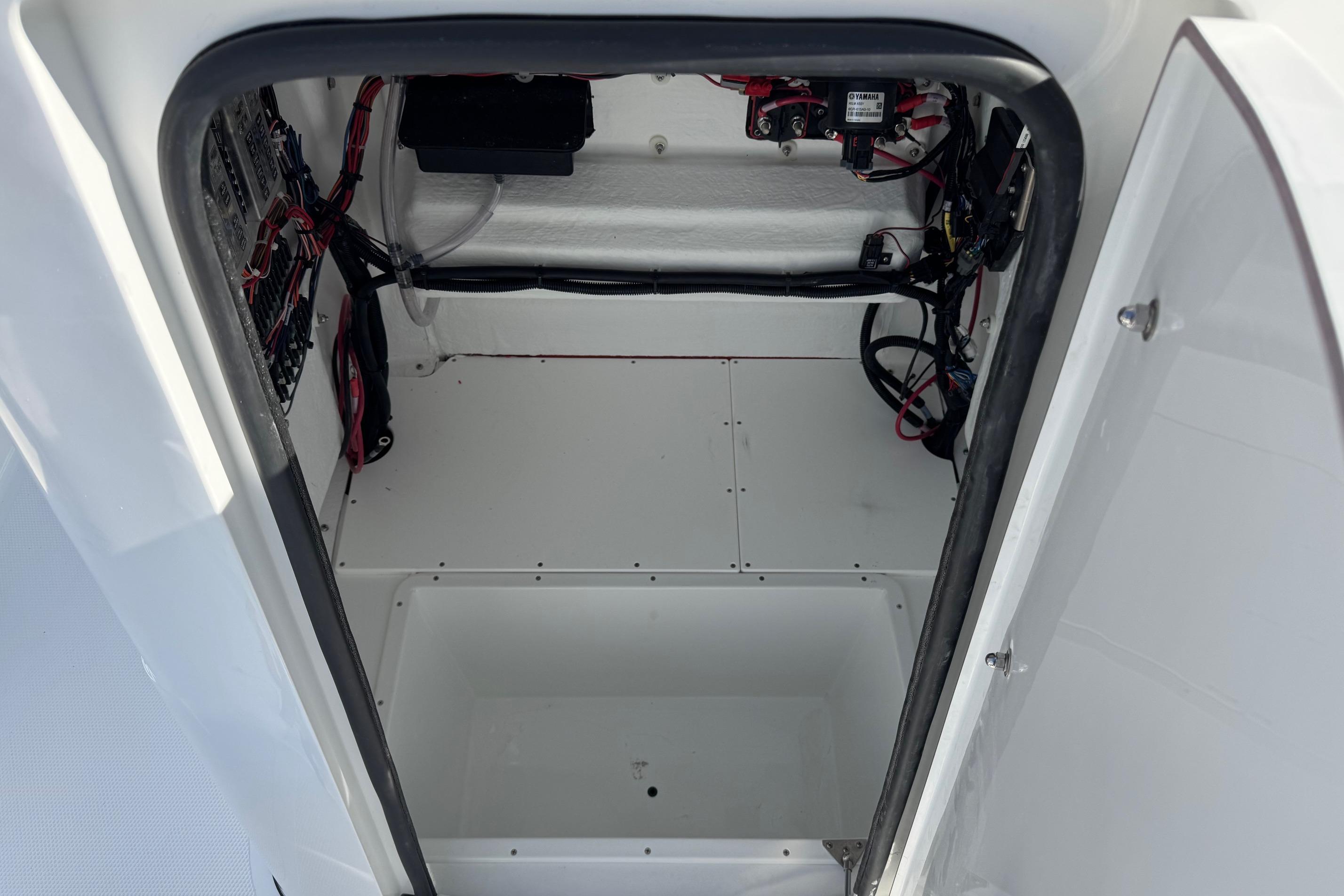 Interior view of 2026 BlackJack 256 Bay boat compartment with wiring and storage space.