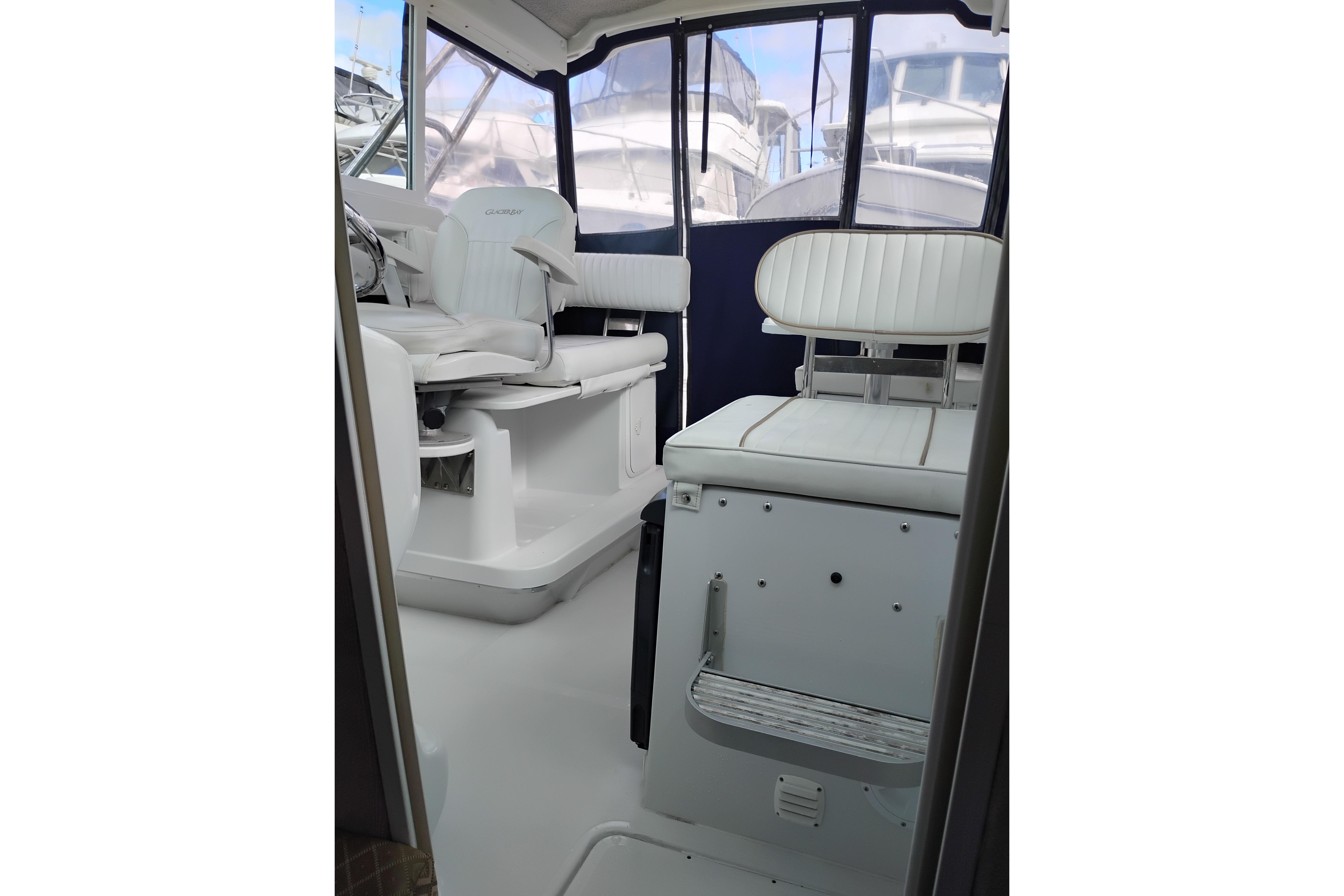 Interior of 2007 Glacier Bay 2685 Coastal Runner boat with white seating and helm.