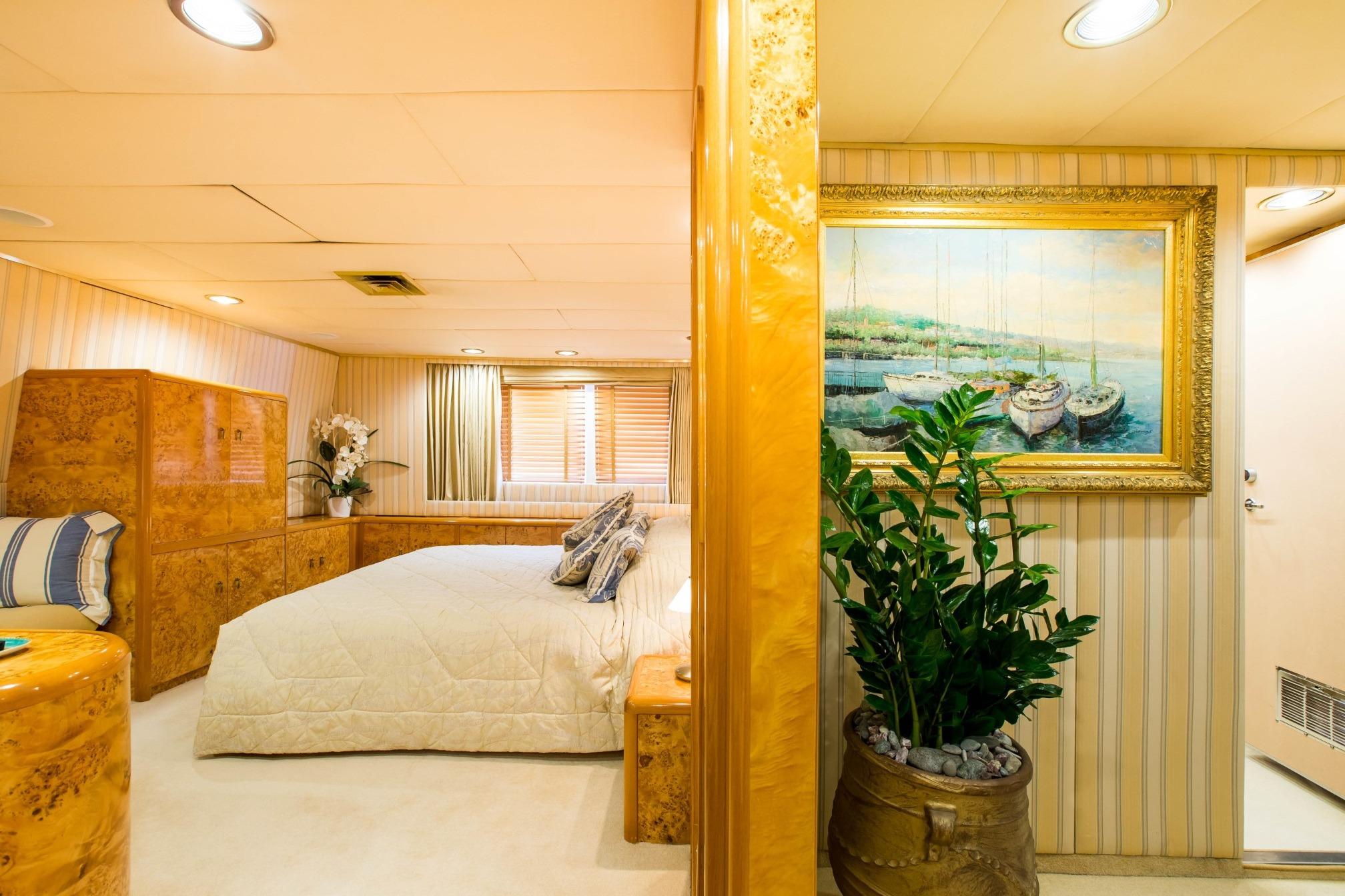 Luxurious bedroom interior on Codecasa ESMERALDA yacht, featuring elegant decor and a framed painting.