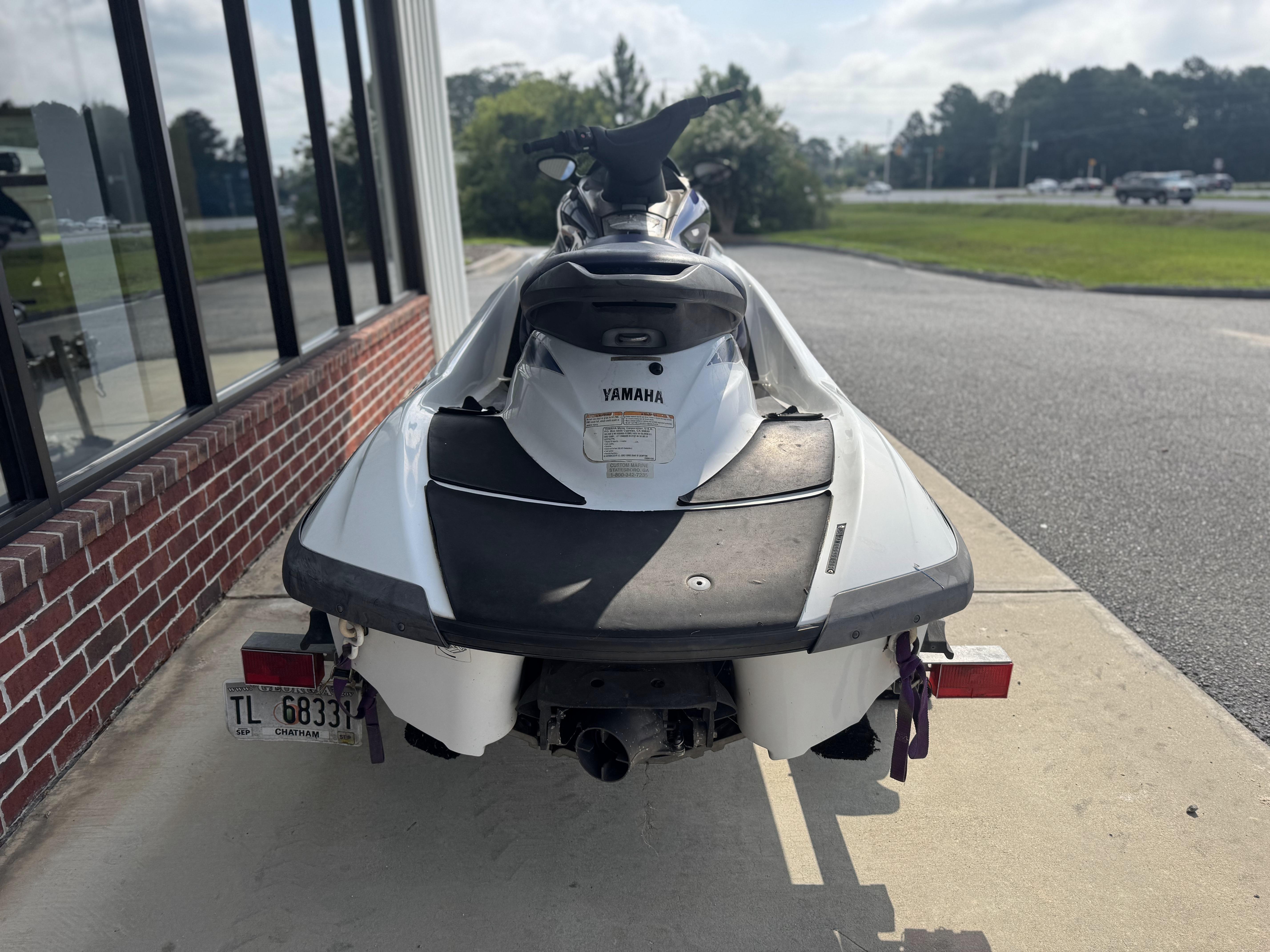 2003 Yamaha WaveRunner FX140 parked on pavement near a brick wall.