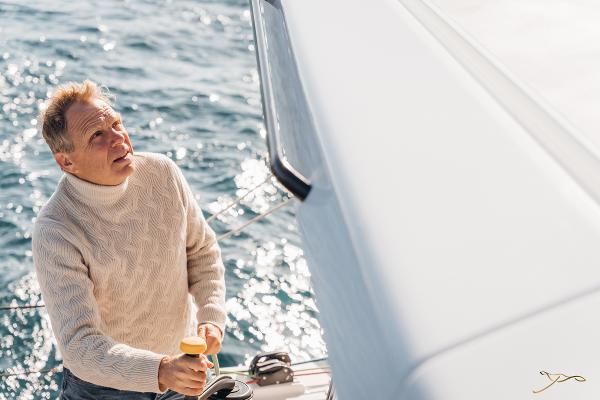 Man sailing on Nautitech 44 Open yacht, 2025 model, in sunny ocean waters.