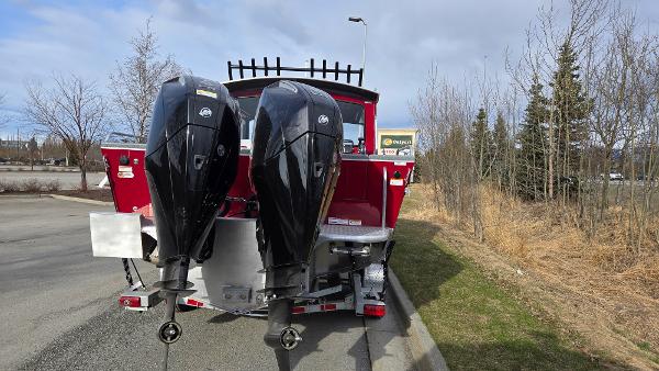2024 Spartan 24 MAXIMUS PRO XL boat with dual outboard motors, parked on a roadside.