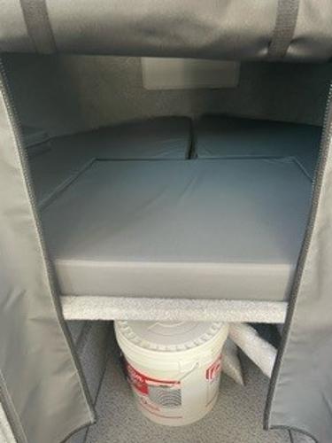 Interior of 2025 Spartan 2600 Olympia boat with storage area and cushions.