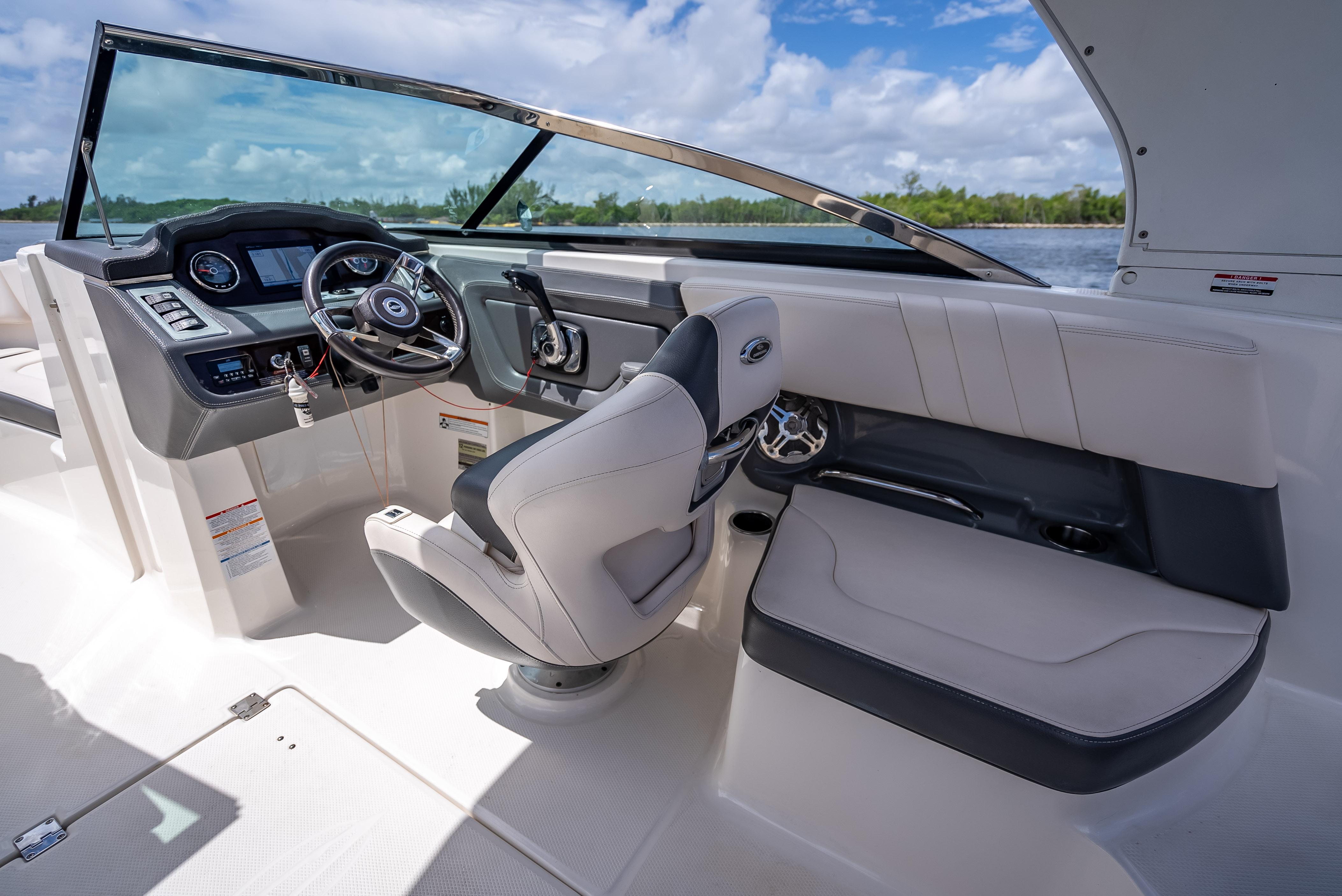 2017 Chaparral 227 SSX boat interior with steering wheel and seating, under a blue sky.