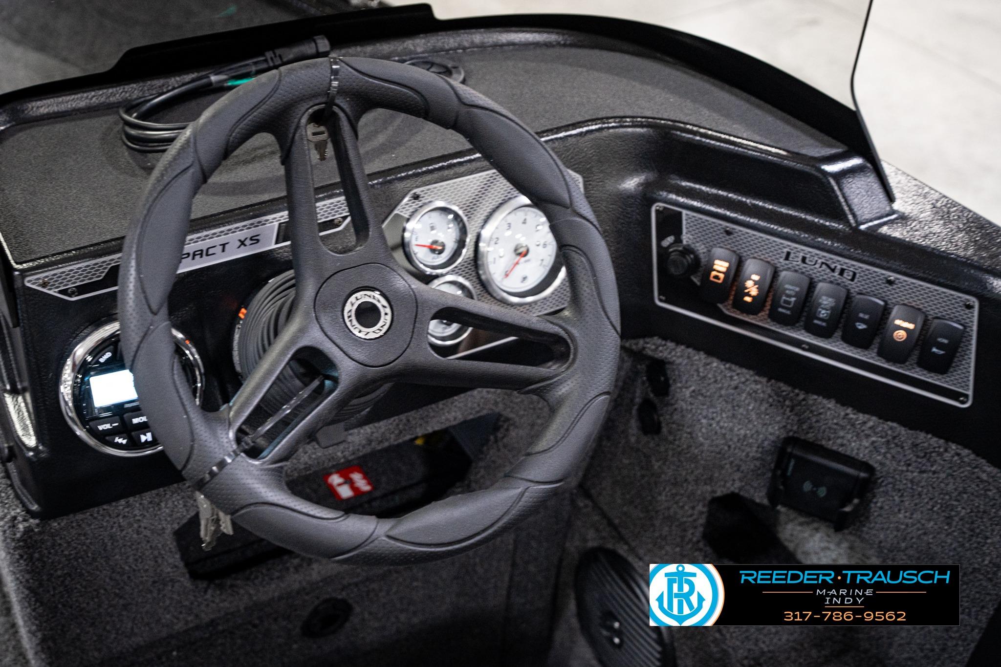 Steering console of 2026 Lund 1775 Impact XS SS boat with gauges and controls.