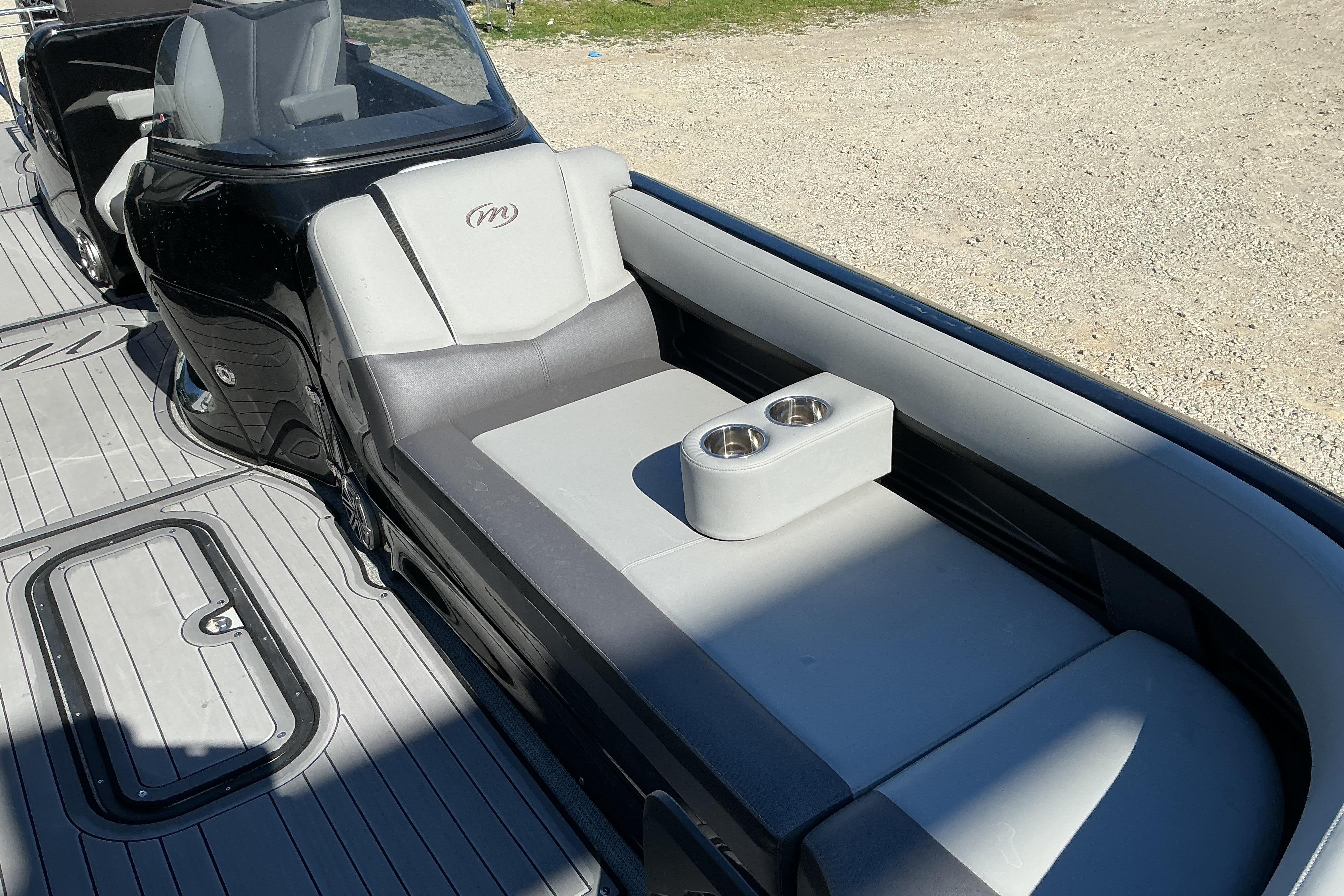 2024 Manitou 25 X-Plode XT SRS boat interior with gray seating and cup holders.