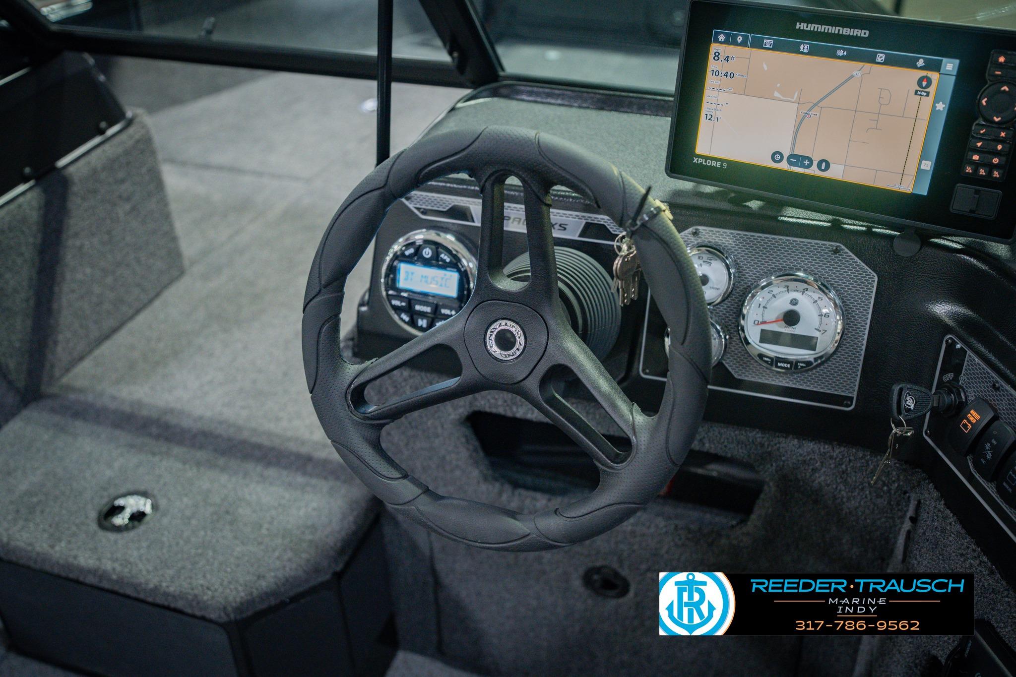 2026 Lund 1775 Impact XS boat dashboard with steering wheel and navigation display.