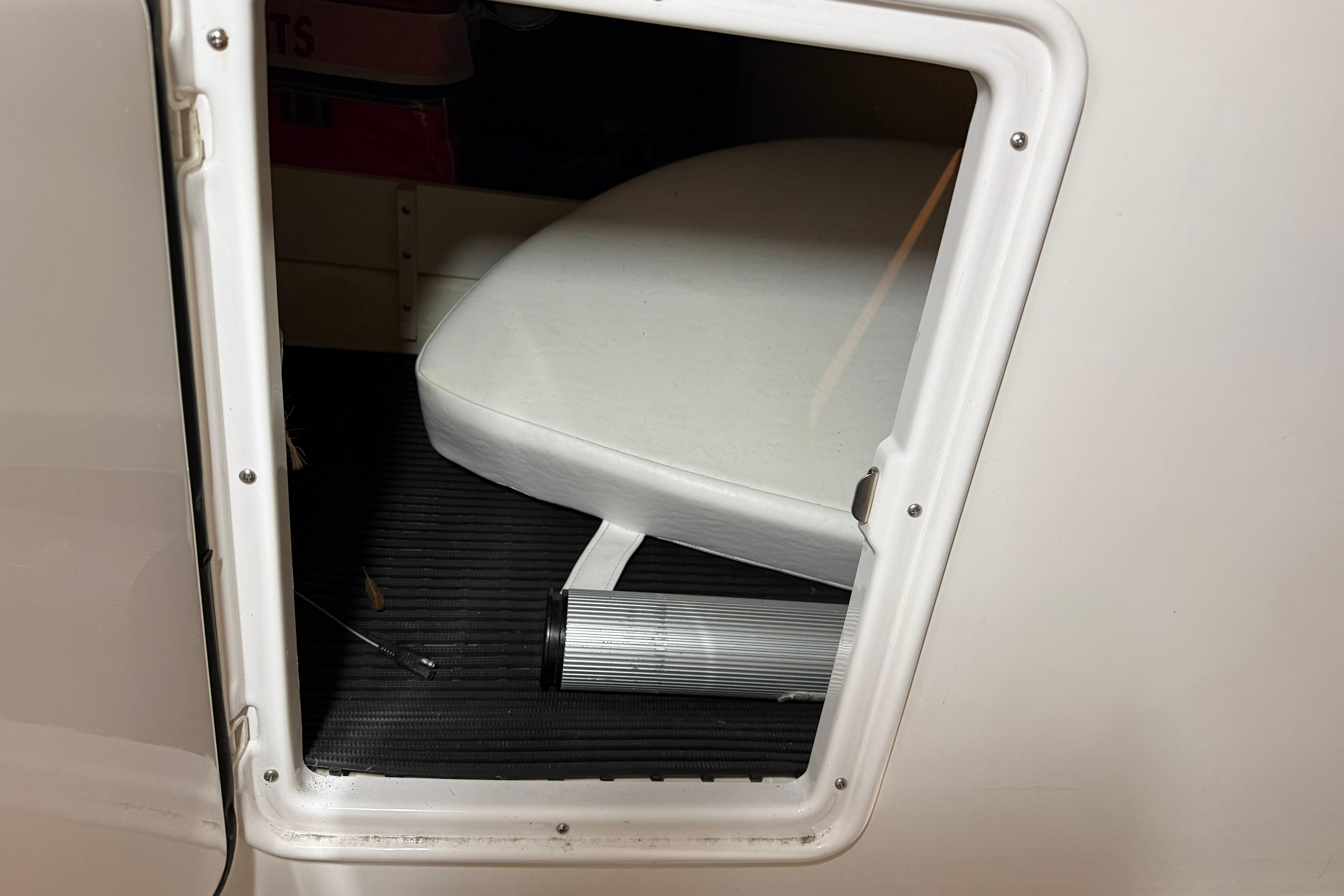 2007 Regal Commodore 3760 IO boat interior storage compartment with white cushion.