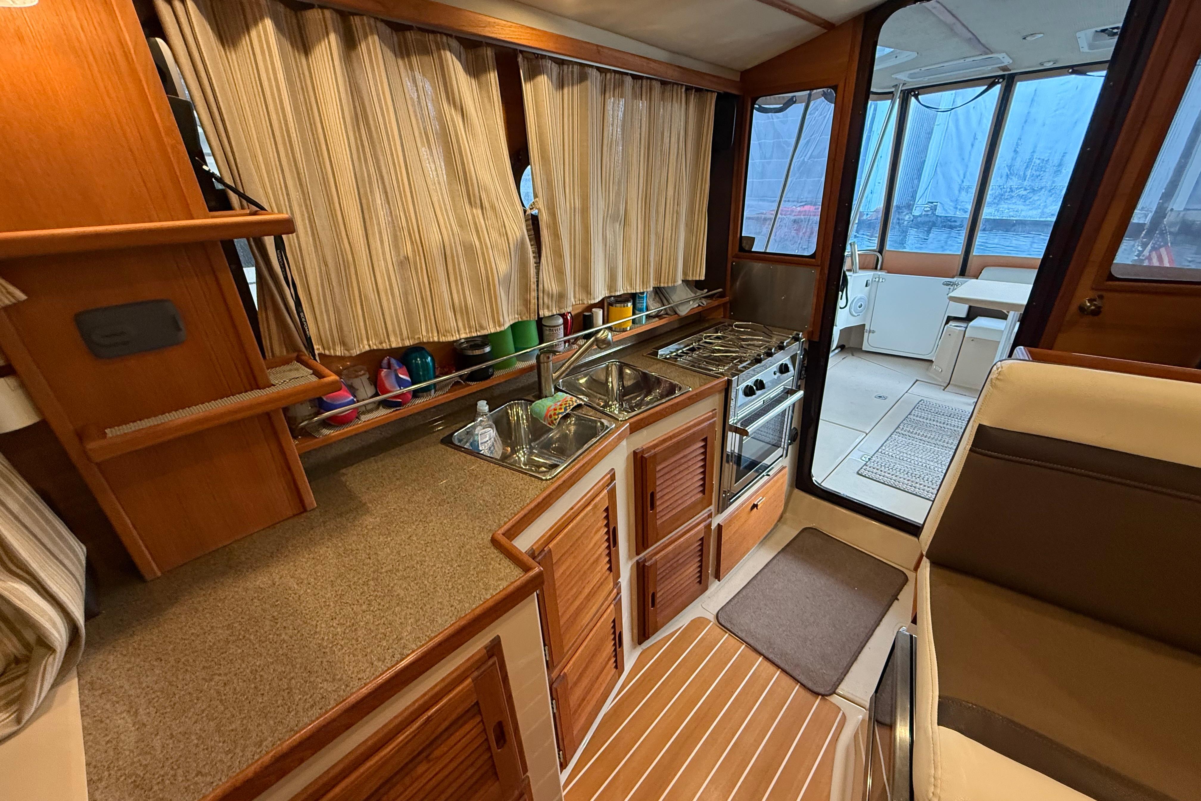2016 Ranger Tugs R-31 CB interior kitchen with stove, sink, and seating area.