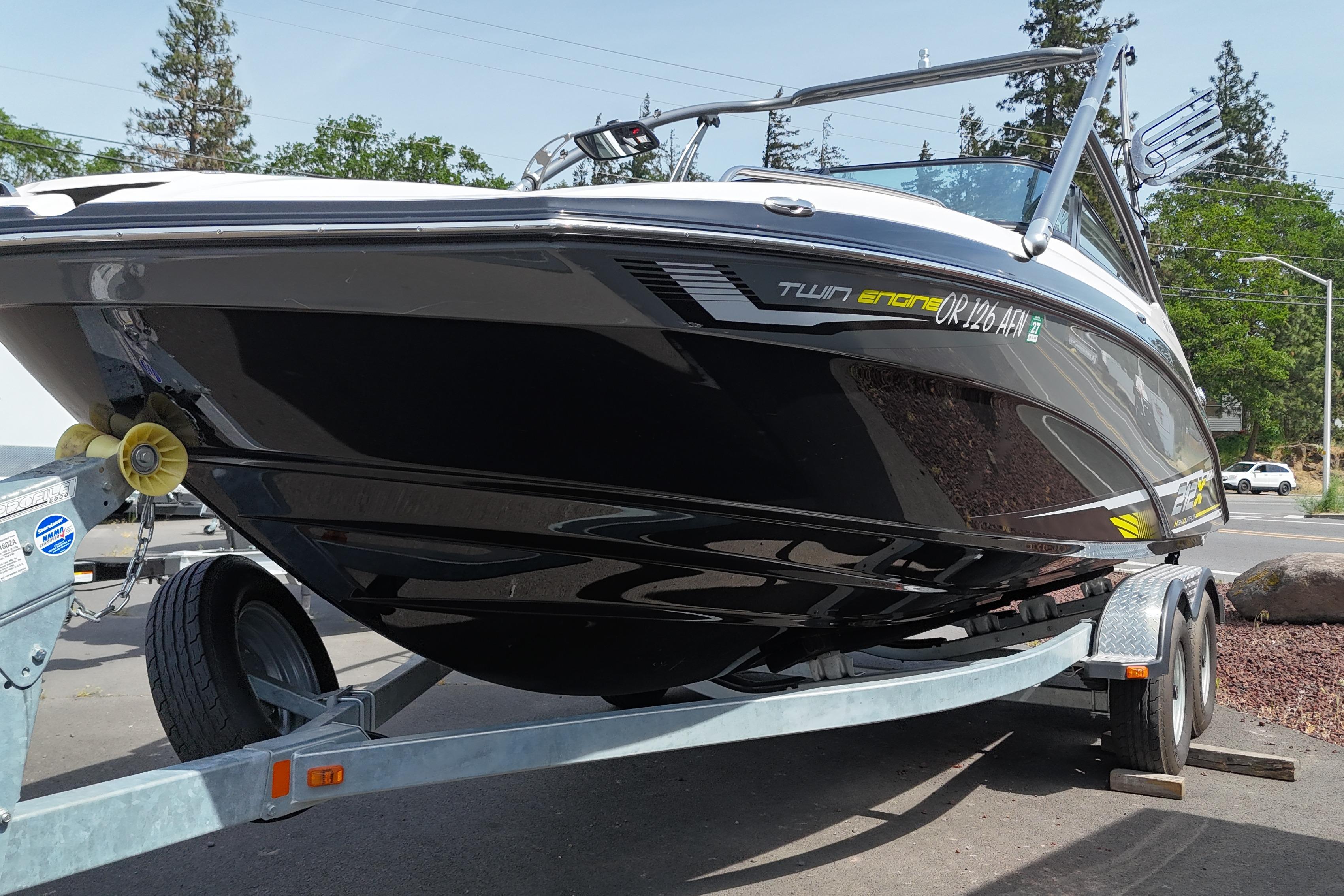 2016 Yamaha Boats 212X on trailer, sleek black design, parked outdoors.