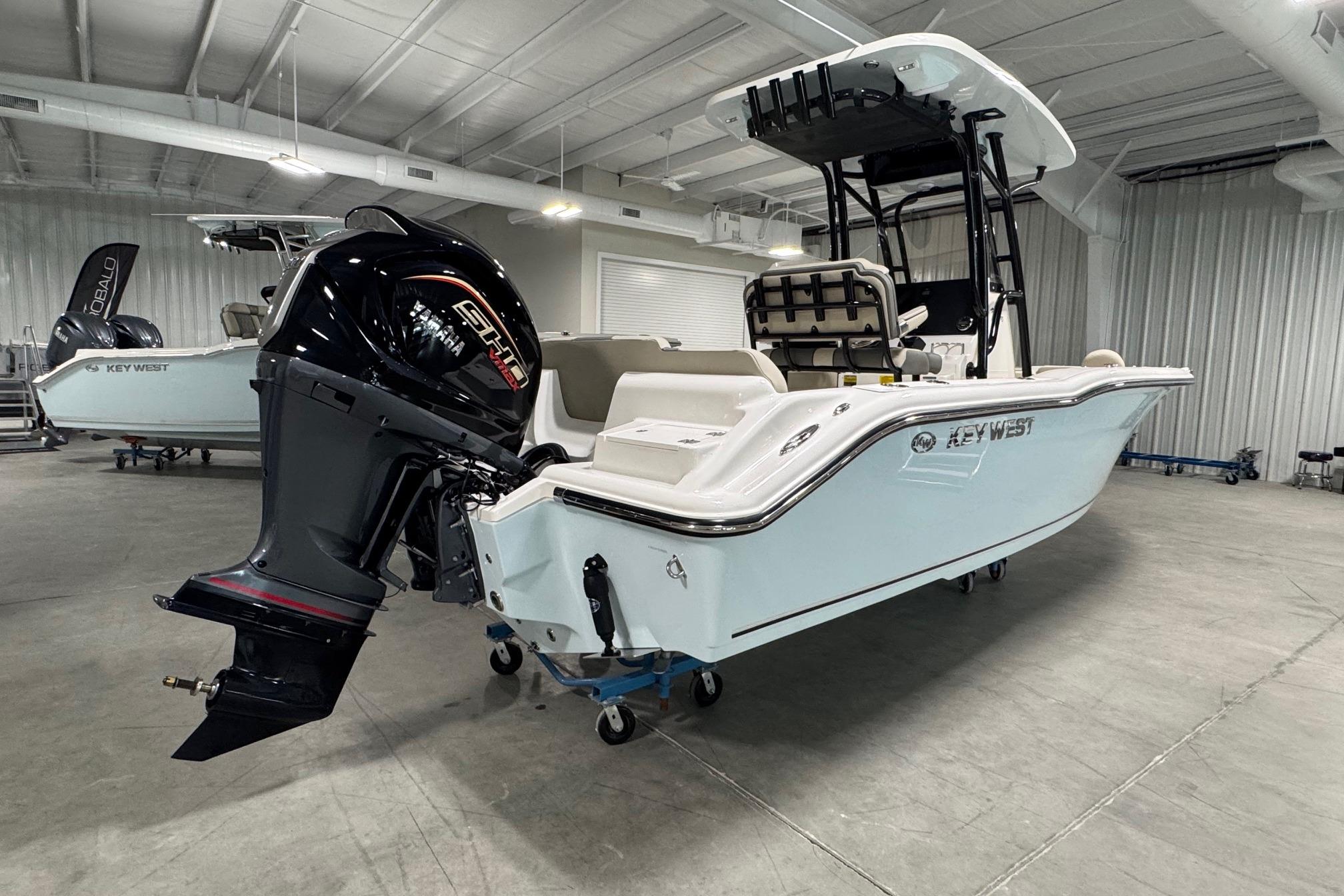 2026 Key West 239 FS boat in showroom, featuring powerful outboard motor.
