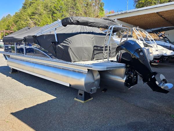 2025 Harris Cruiser 230 pontoon boat with outboard motor, parked outdoors.