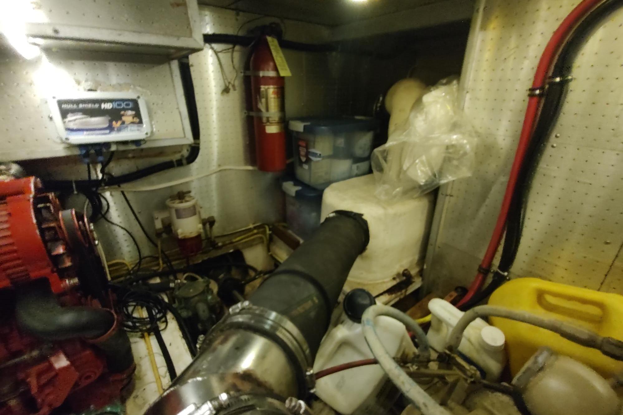 Engine room of 1989 Hyatt Double Cabin Motoryacht with equipment and fire extinguisher.