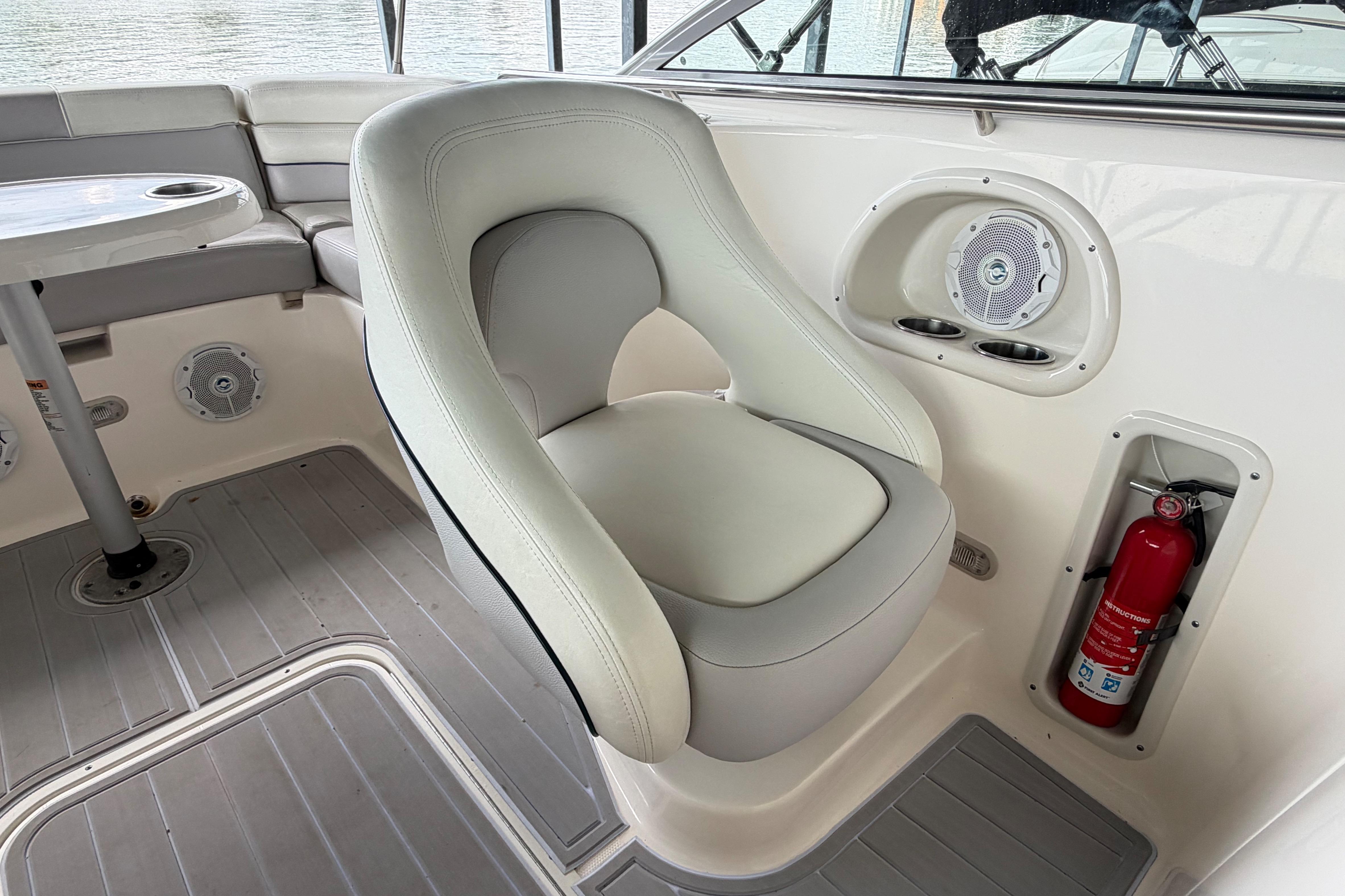 Luxurious seating area on a 2010 Bryant 255 boat with speaker and fire extinguisher.
