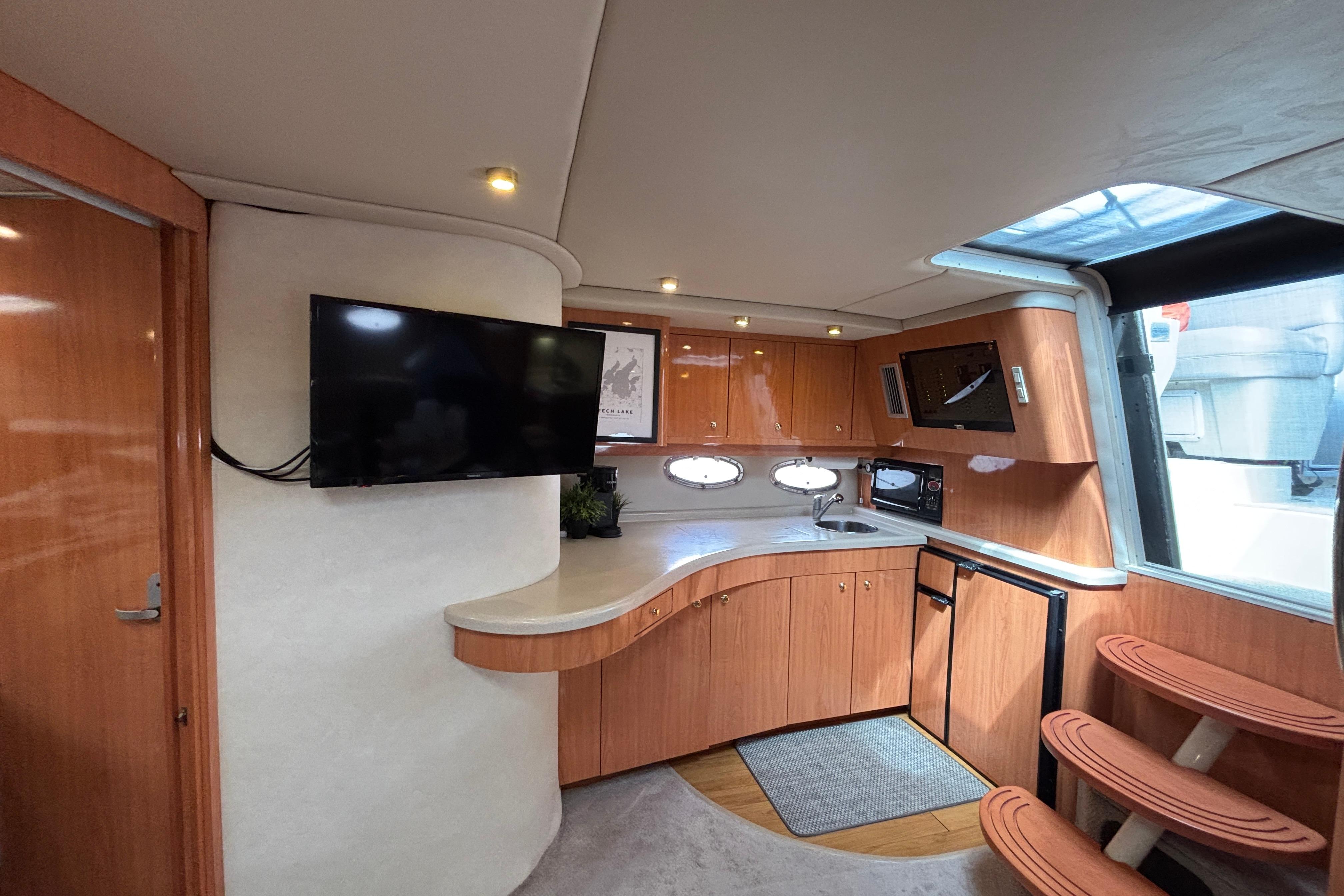 Luxurious interior of 2000 Regal Commodore 4160 yacht with modern kitchen and TV.