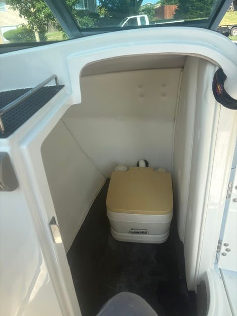 The image shows a small cabin with a portable toilet inside a Cobalt 240 boat.