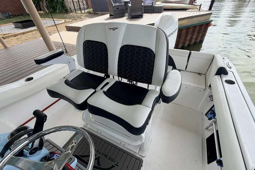 2024 Tidewater 232 LXF boat interior with dual captain's chairs and steering wheel.