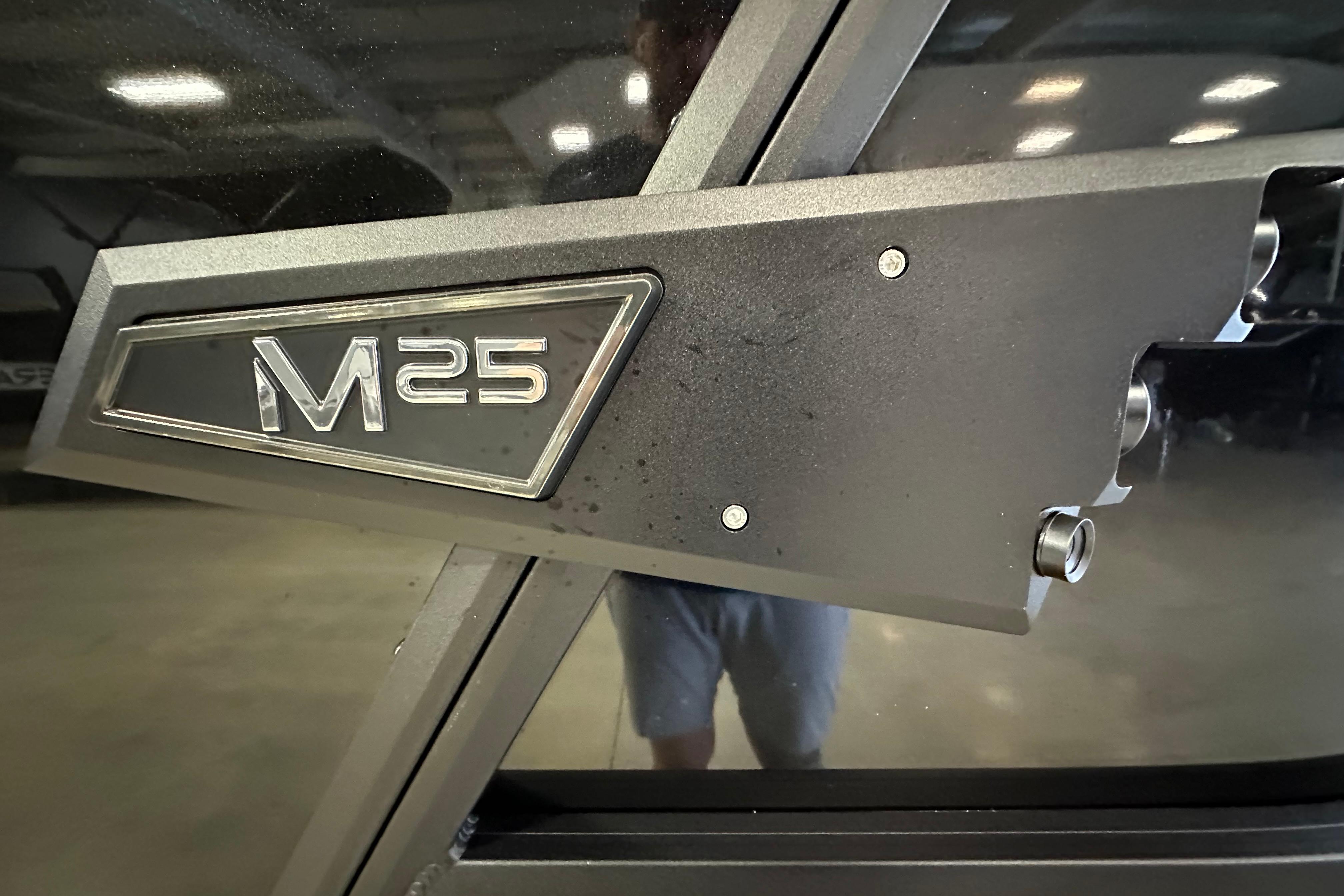 Close-up of 2026 Alera M25L emblem on a sleek, metallic surface.