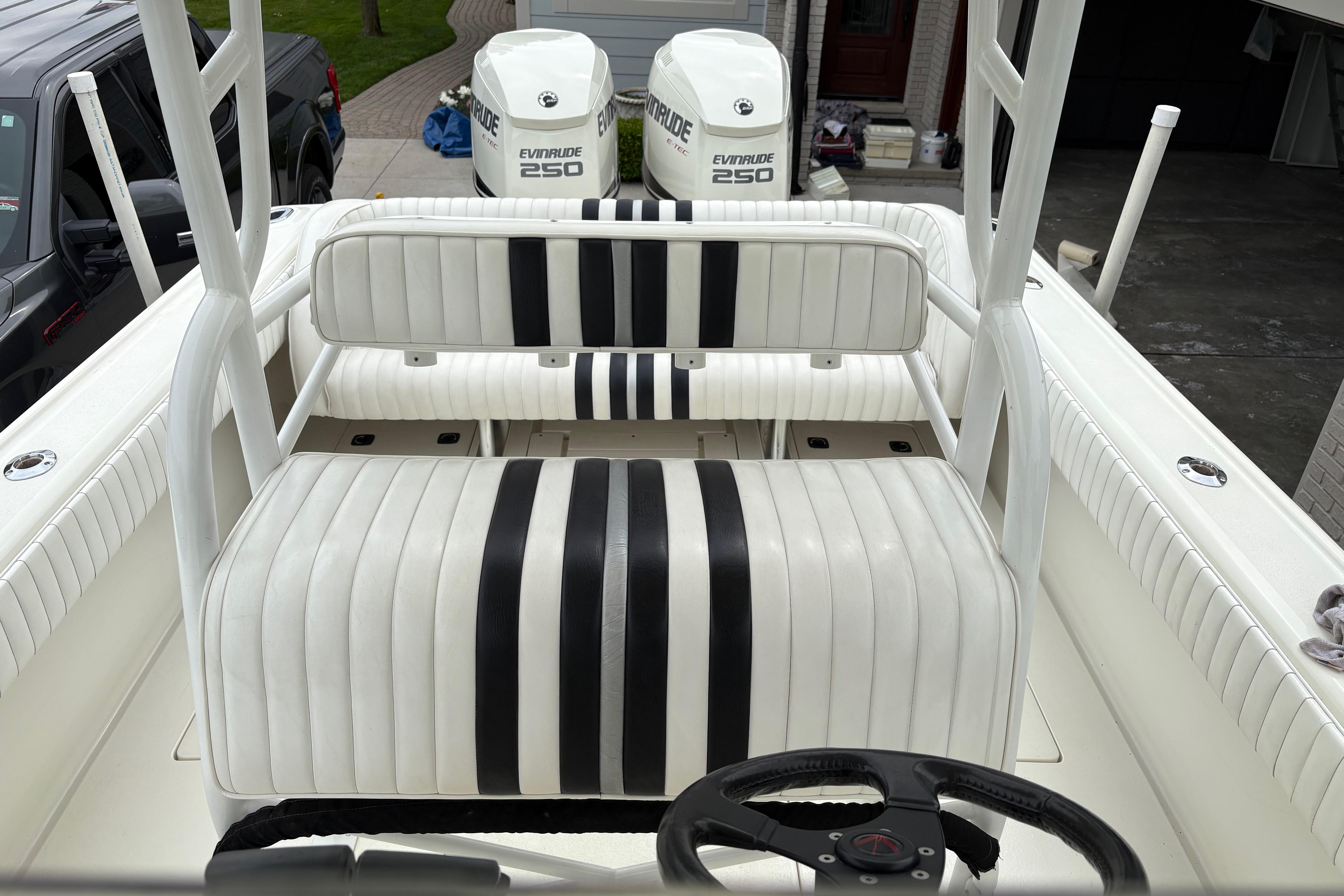 1994 Intrepid 30 Open Cuddy boat interior with striped seating and dual Evinrude 250 engines.