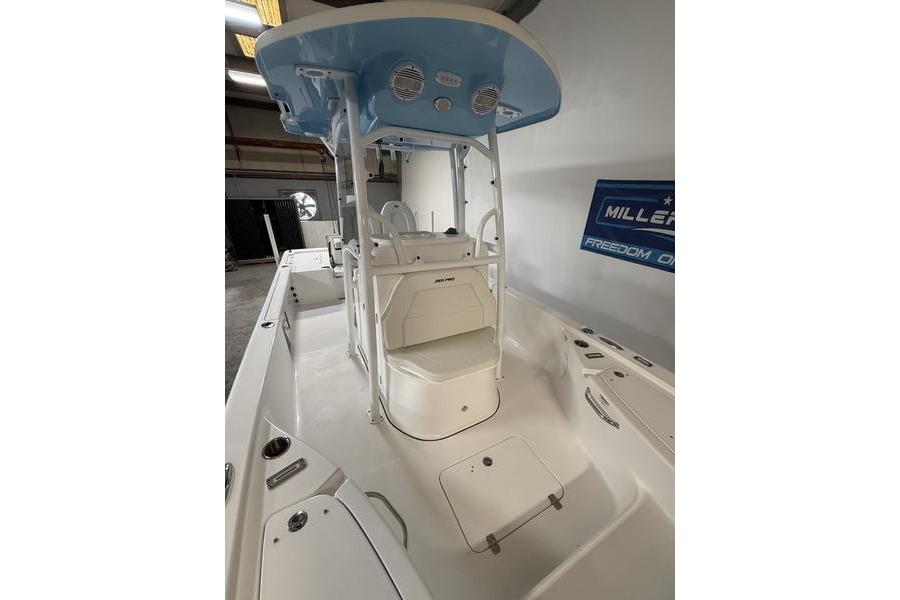 2026 Sea Pro 250 Bay boat interior with seating and console, in a showroom setting.