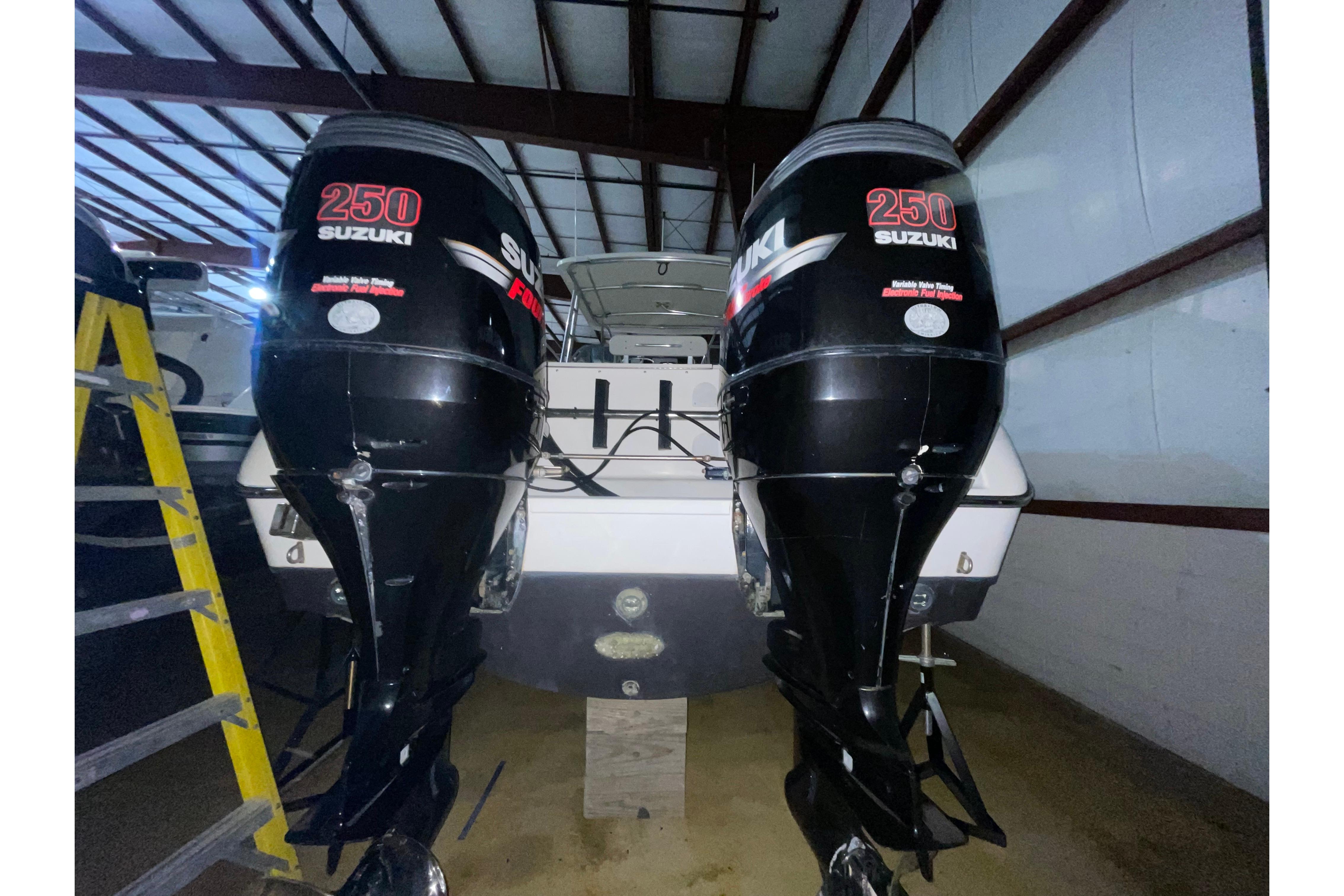 2000 Pursuit 3070 Offshore Center Console with twin Suzuki 250 engines in storage.