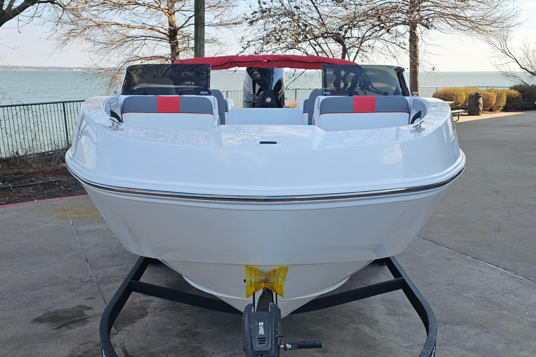 2026 Tahoe T21 boat on trailer by lakeside, featuring sleek design and modern seating.