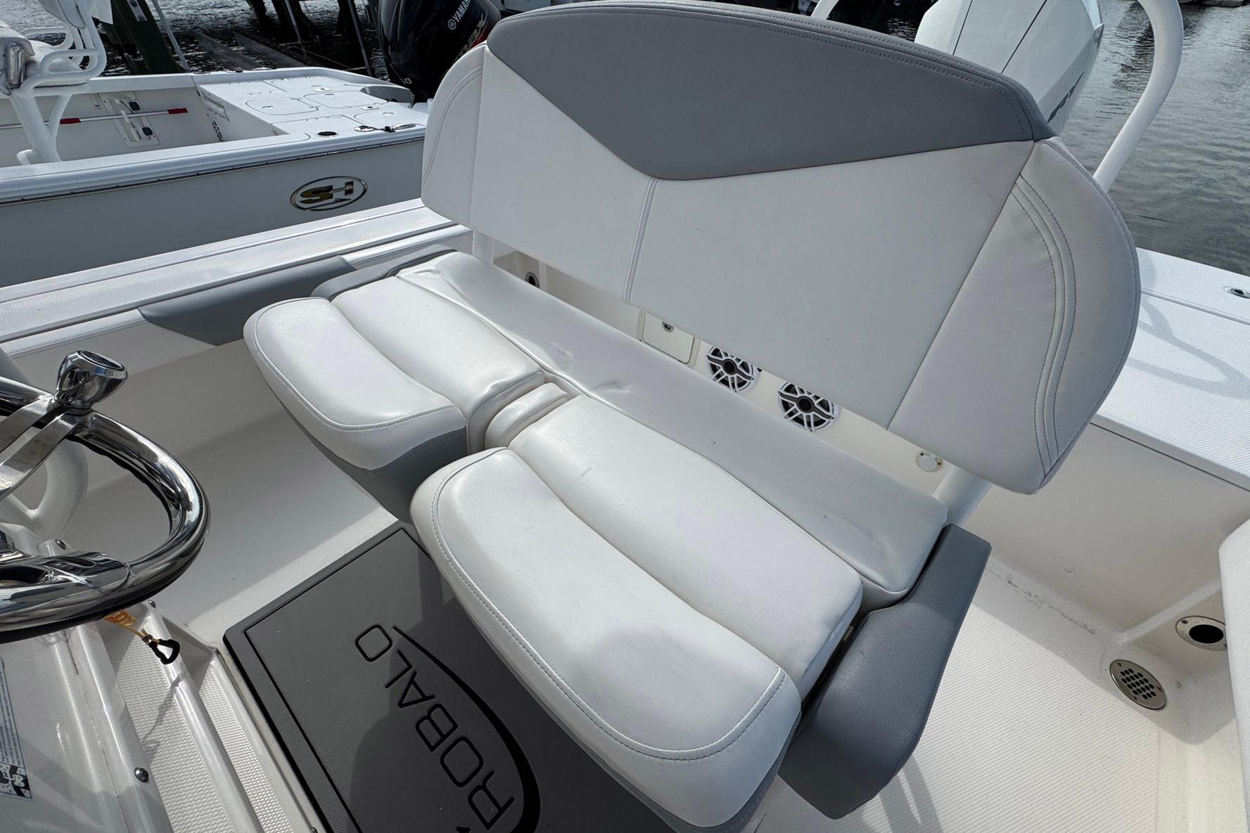 2021 Robalo 246 Cayman boat interior with white cushioned seating and steering wheel.