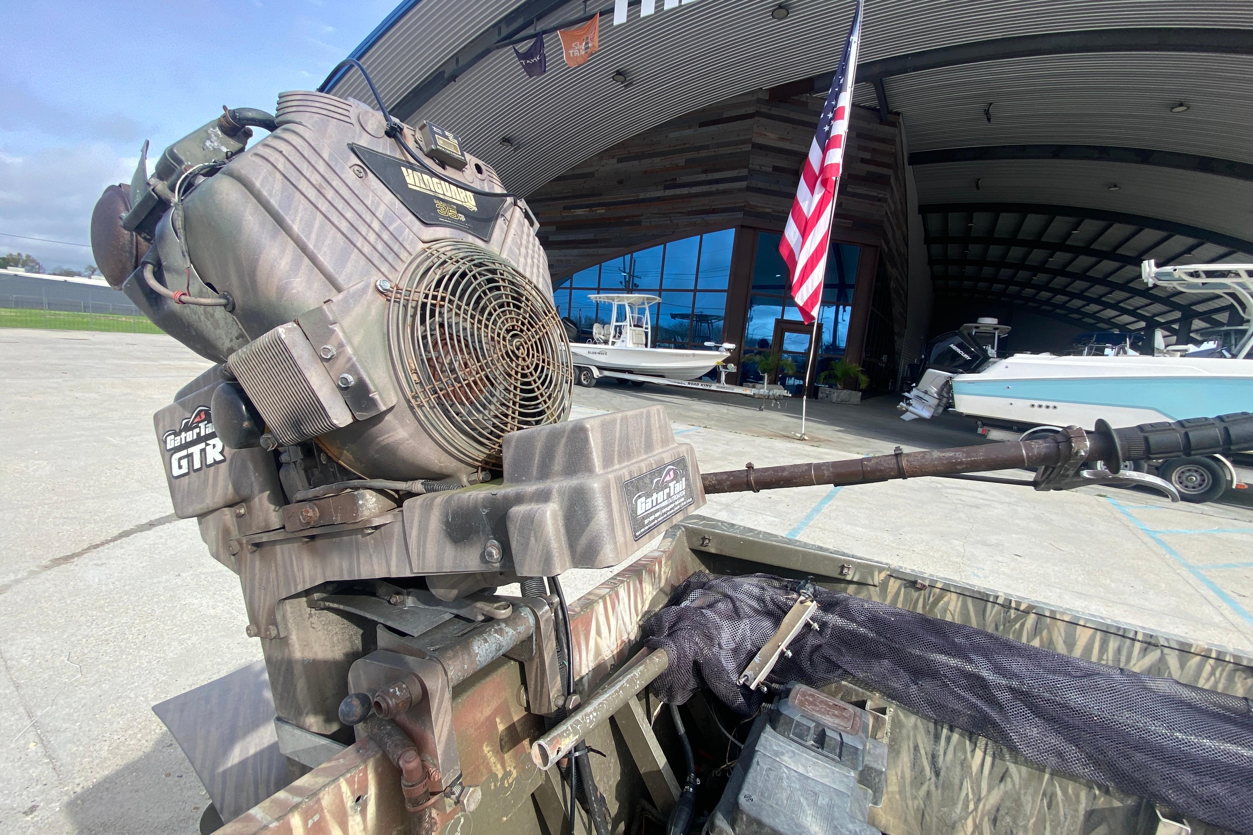 2009 Gator Trax MUD BUDDY boat motor at marina with American flag.