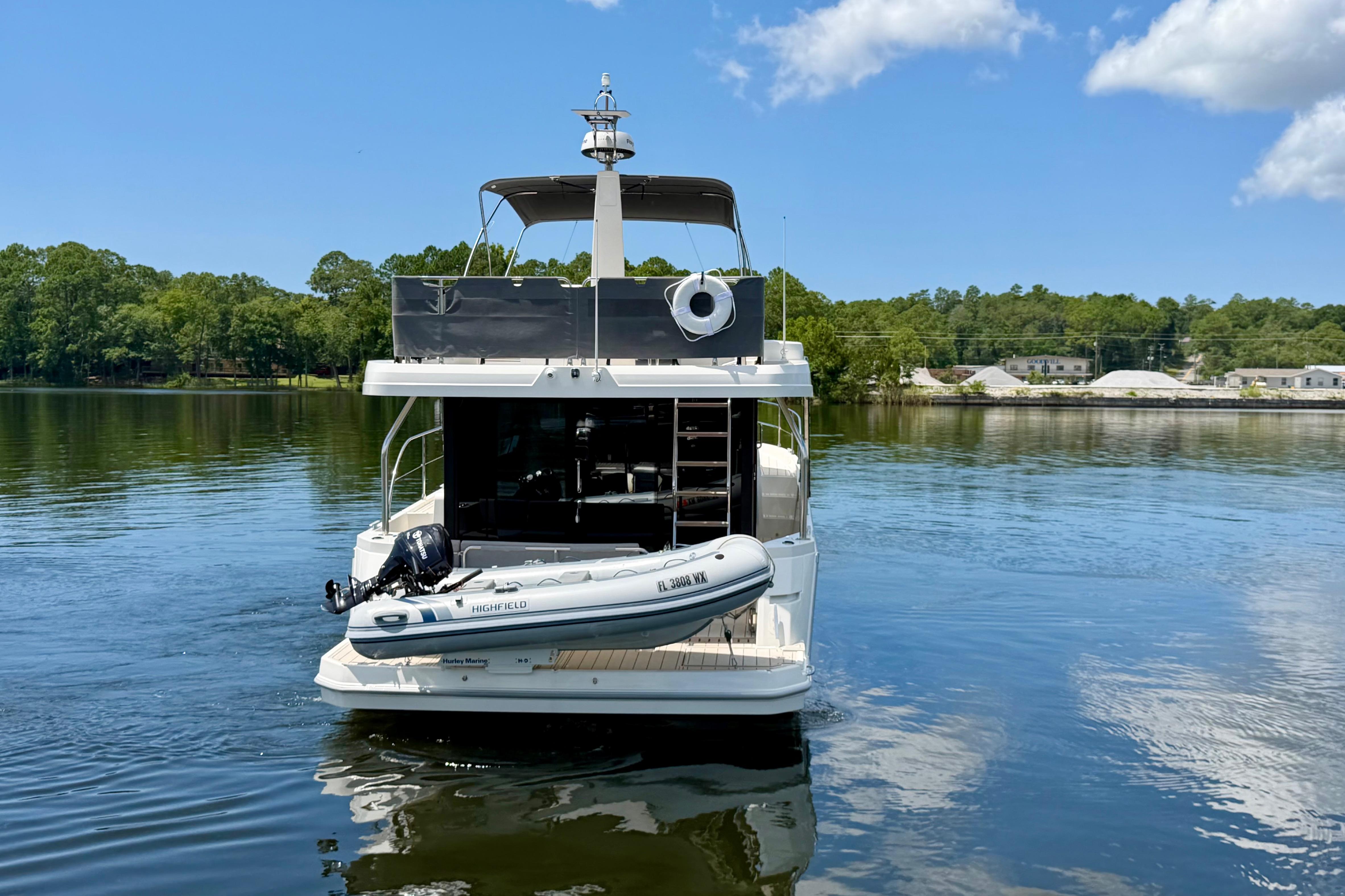 2025 Beneteau Swift Trawler 41 Fly on serene lake with inflatable boat.