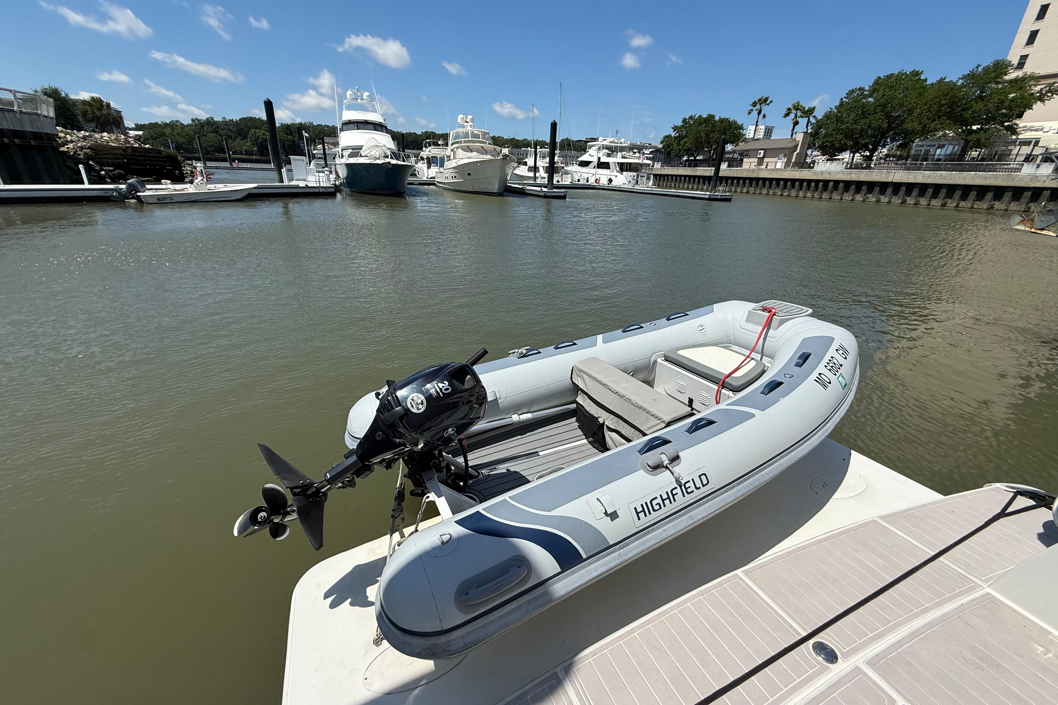 Highfield inflatable boat docked near a 2006 Carver 43 Motor Yacht in a marina.