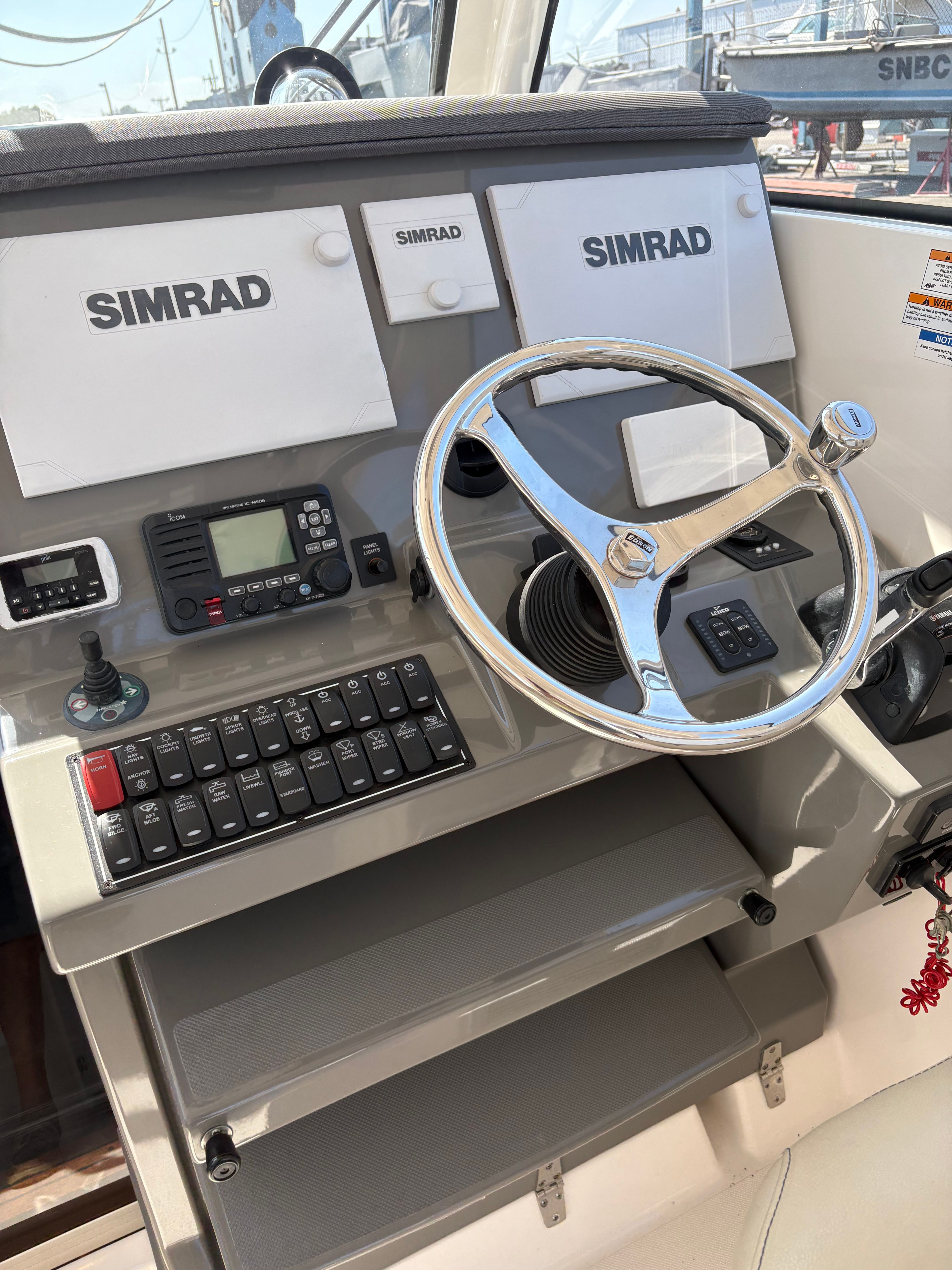 Helm of 2017 Pursuit OS 355 Offshore boat with Simrad electronics and steering wheel.