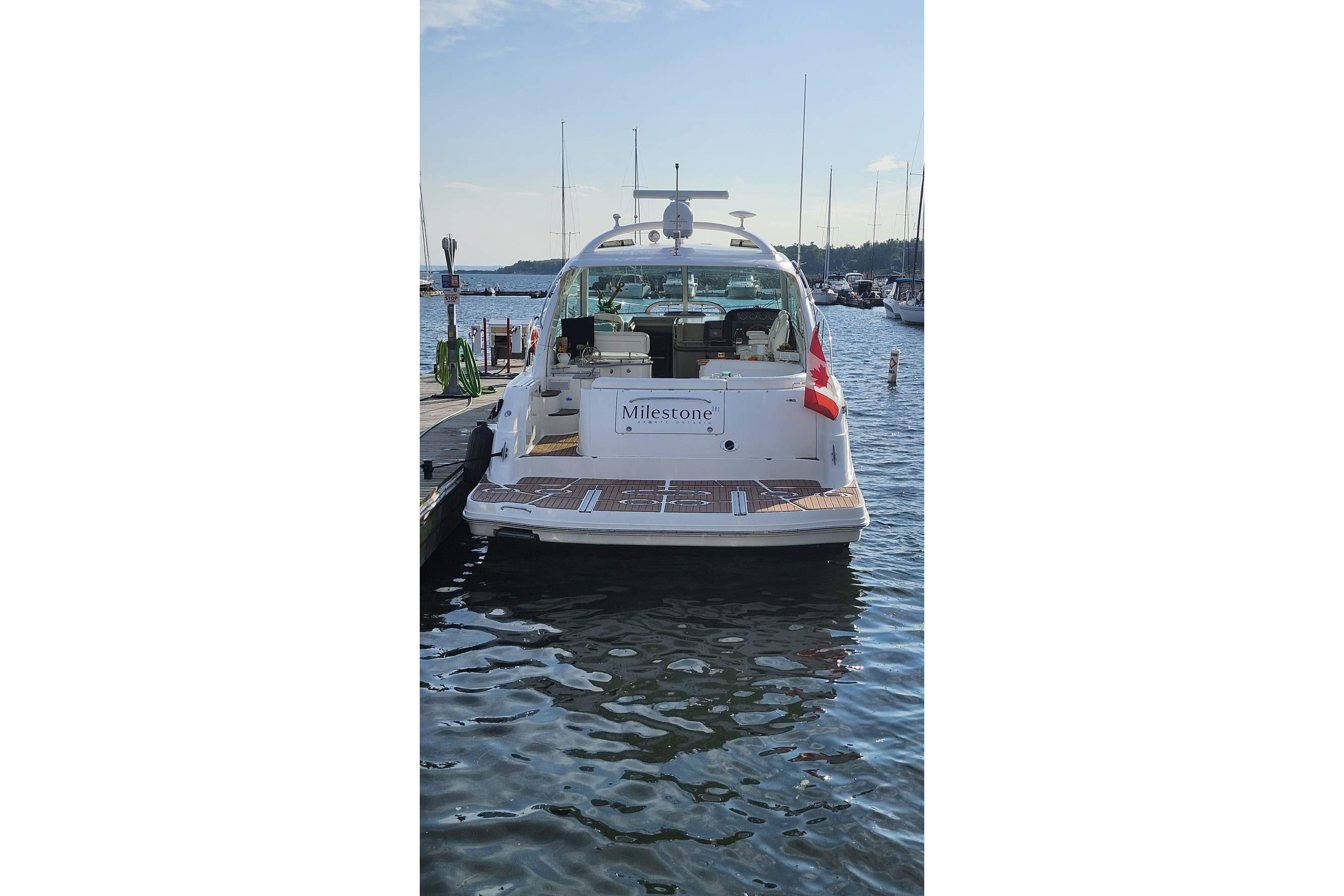 2007 Sea Ray 480 Sundancer yacht docked at marina, rear view with Canadian flag.