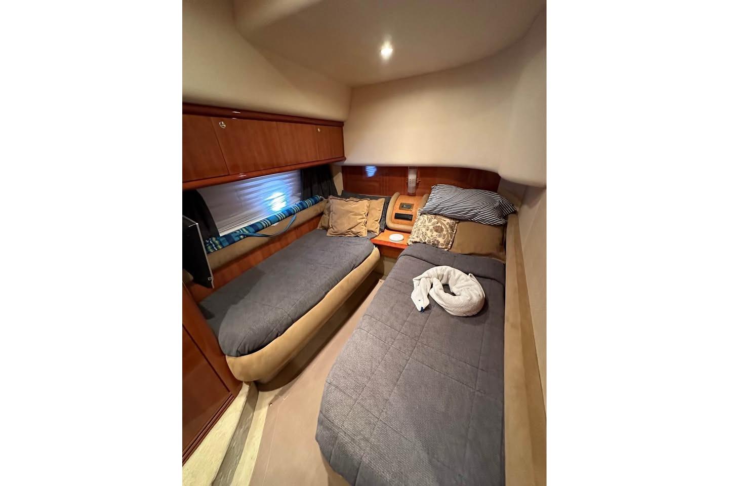 Luxurious twin cabin interior of 2004 Azimut 55E yacht with cozy bedding.