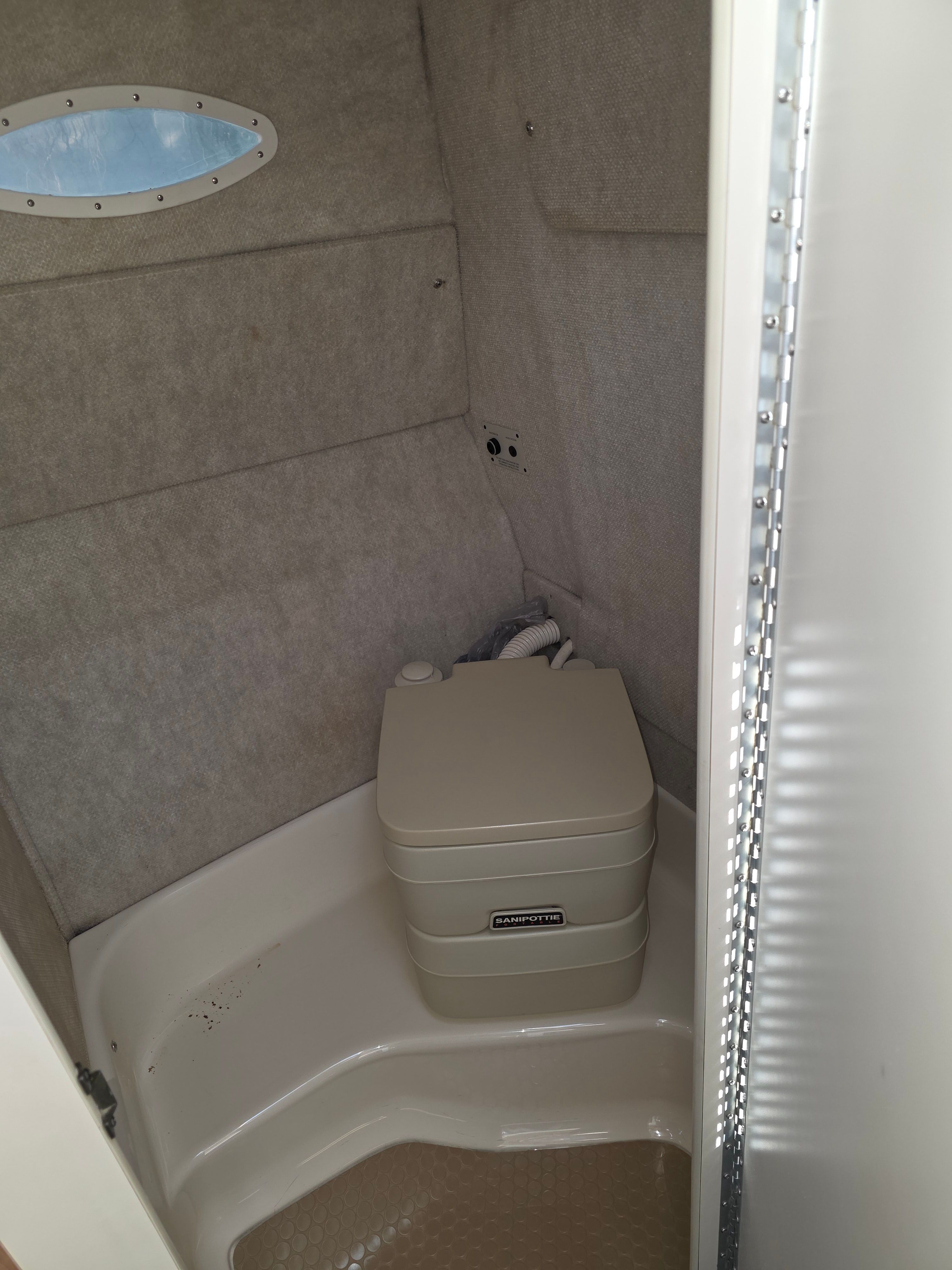 Interior of a 1997 Sea Ray 240 Sundeck featuring a portable toilet.