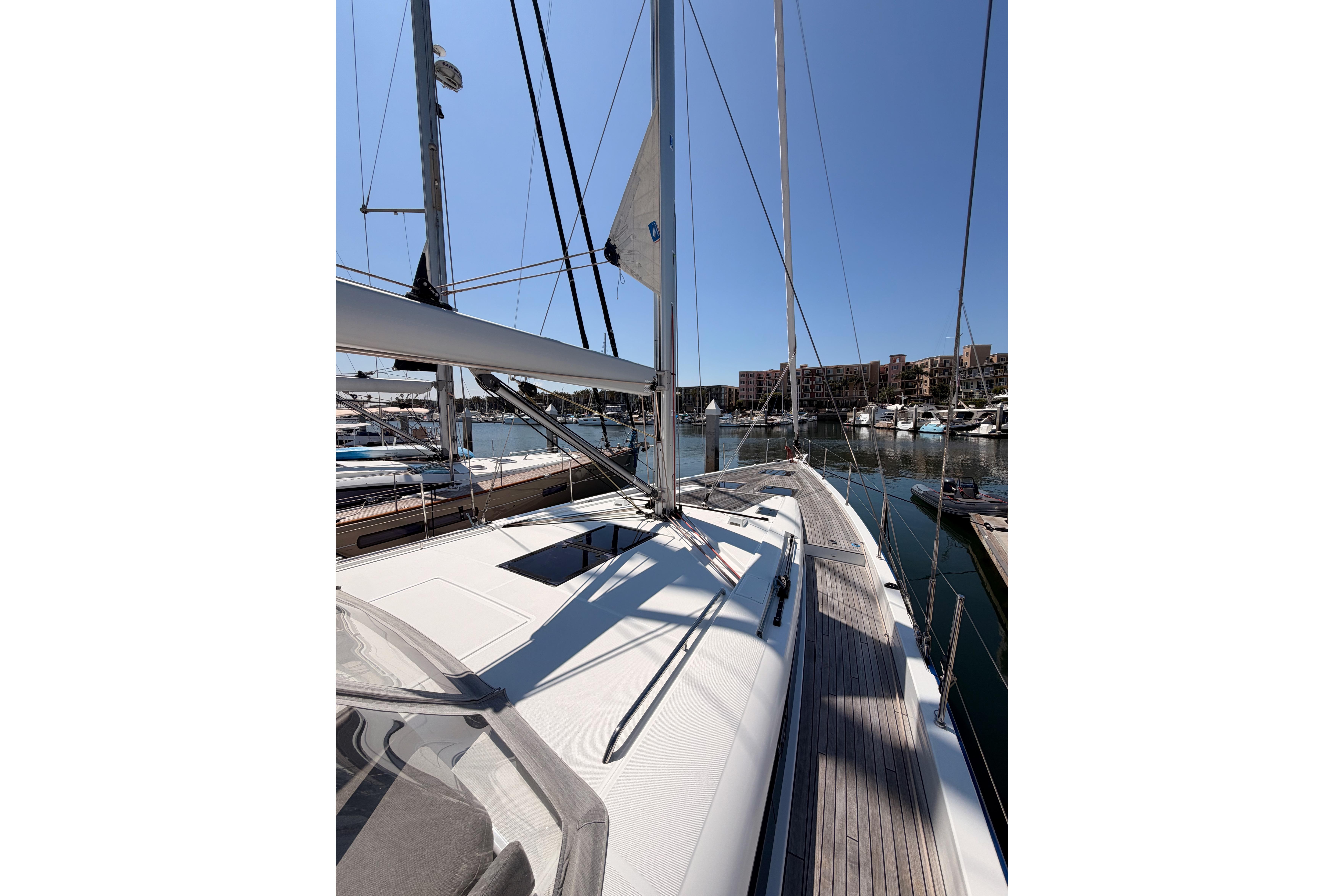 2022 Beneteau Oceanis Yacht 54 docked in a marina under clear blue skies.
