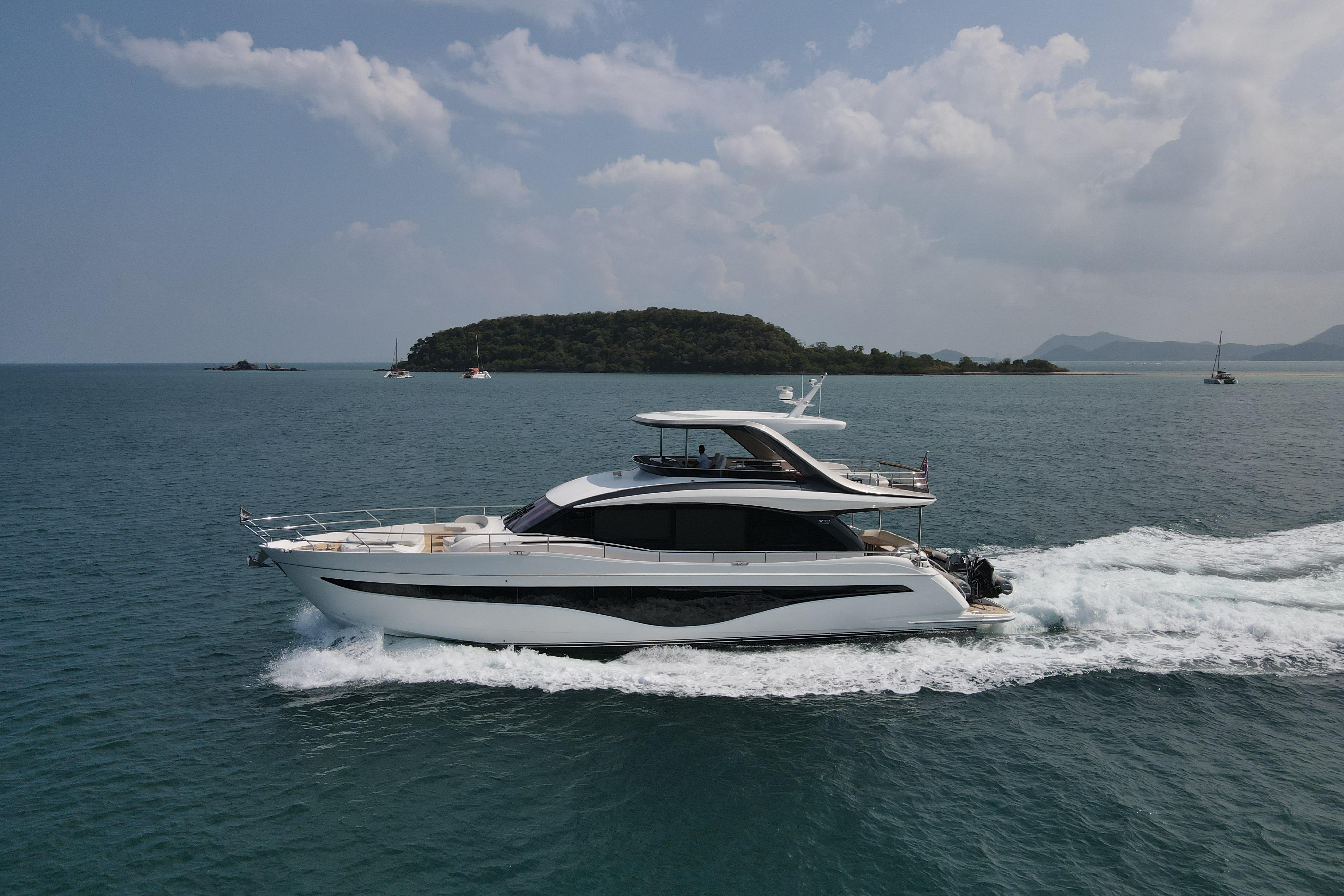 Luxurious 2023 Princess Y72 yacht cruising on open sea with scenic island backdrop.