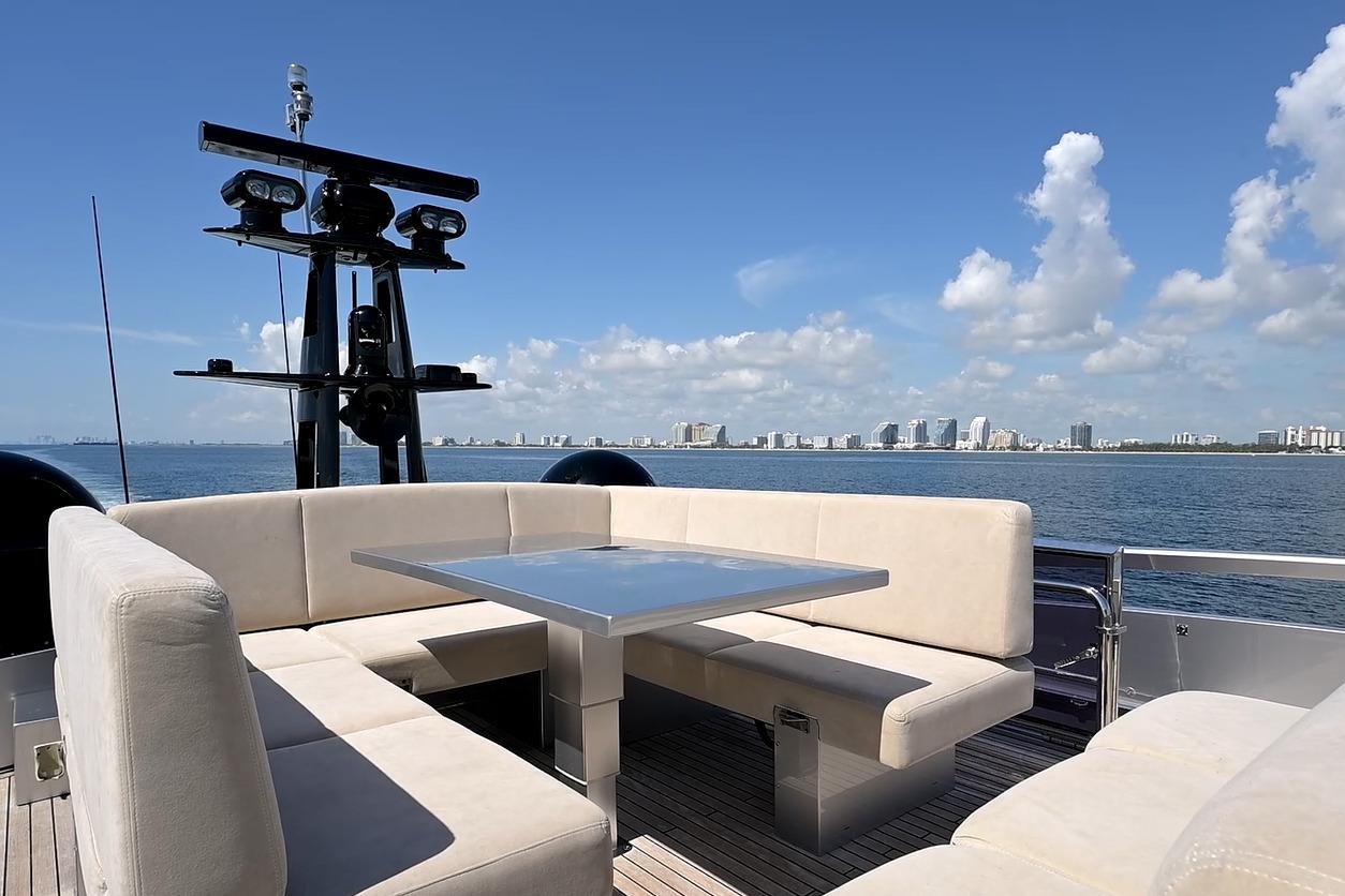 Luxurious seating area on 2015 Pershing 92 yacht with ocean and city skyline views.